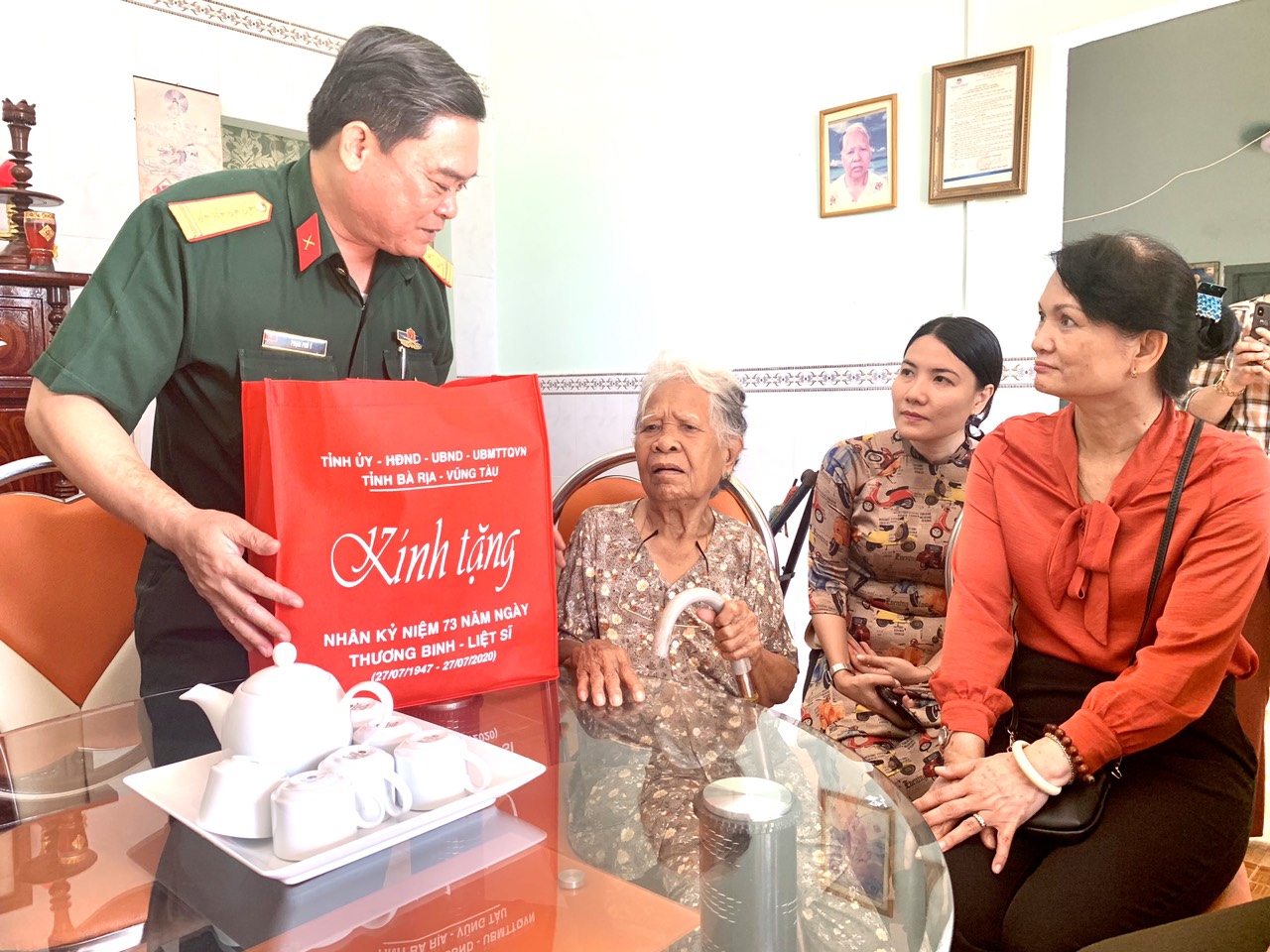 Đại tá Phạm Phú Ý, Ủy viên Ban Thường vụ Tỉnh ủy, Chỉ huy trưởng Bộ CHQS tỉnh trao quà cho Mẹ VNAH Dương Thị Đành (phường Hắc Dịch, TX.Phú Mỹ). Ảnh: MINH NHÂN