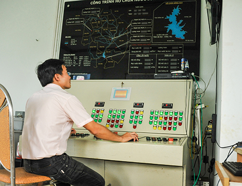 Kỹ sư Trạm quản lý khai thác các công trình thủy lợi đầu mối hồ Sông Ray theo dõi vận hành tràn xả lũ qua hệ thống điều khiển từ xa.