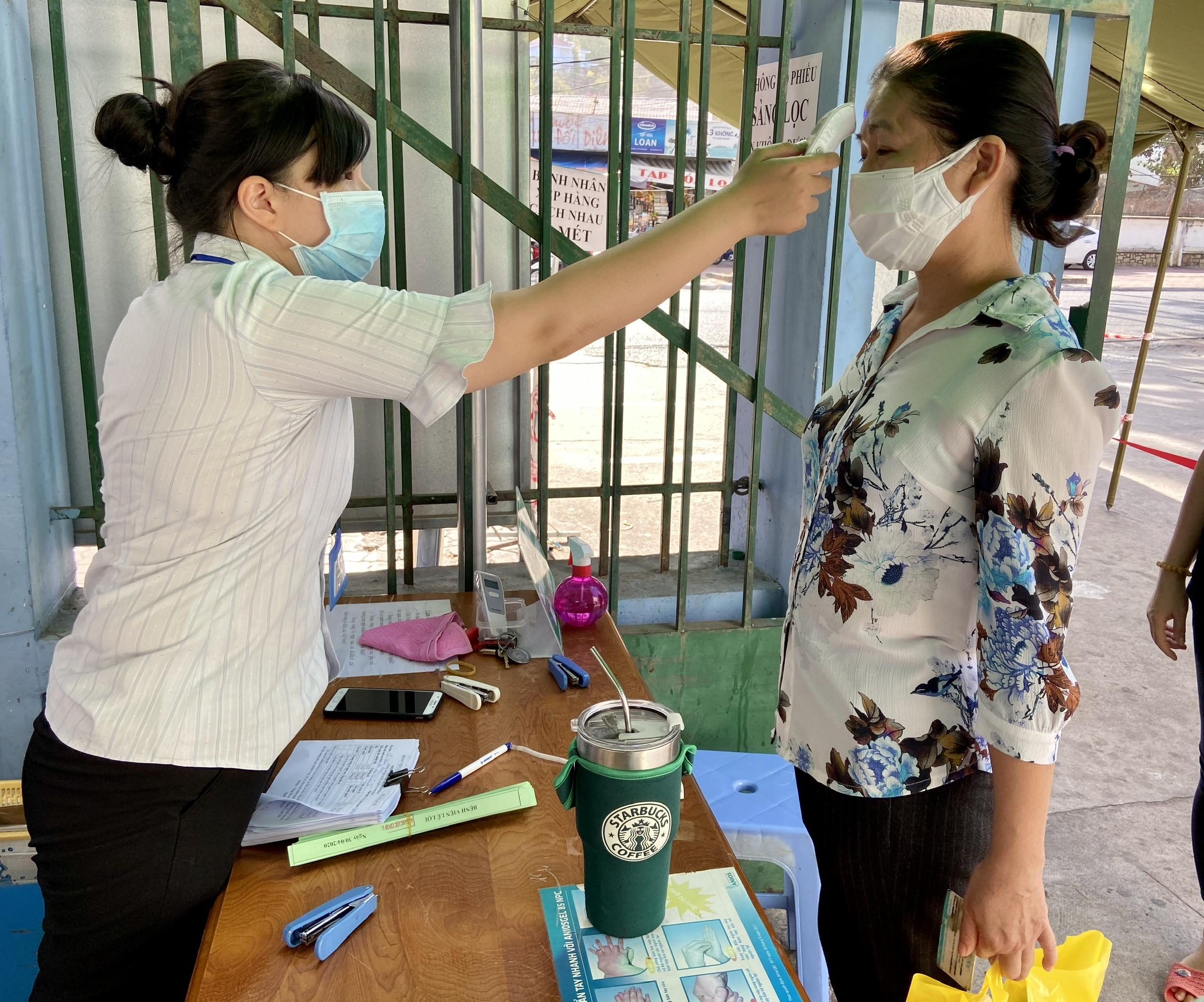 Người dân cần thực hiện các biện pháp phòng, chống dịch như: Đeo khẩu trang nơi công cộng, đo thân nhiệt, rửa tay bằng dung dịch sát khuẩn. Trong ảnh: Nhân viên của Bệnh viện Lê Lợi đo thân nhiệt cho người dân tháng 4/2020.