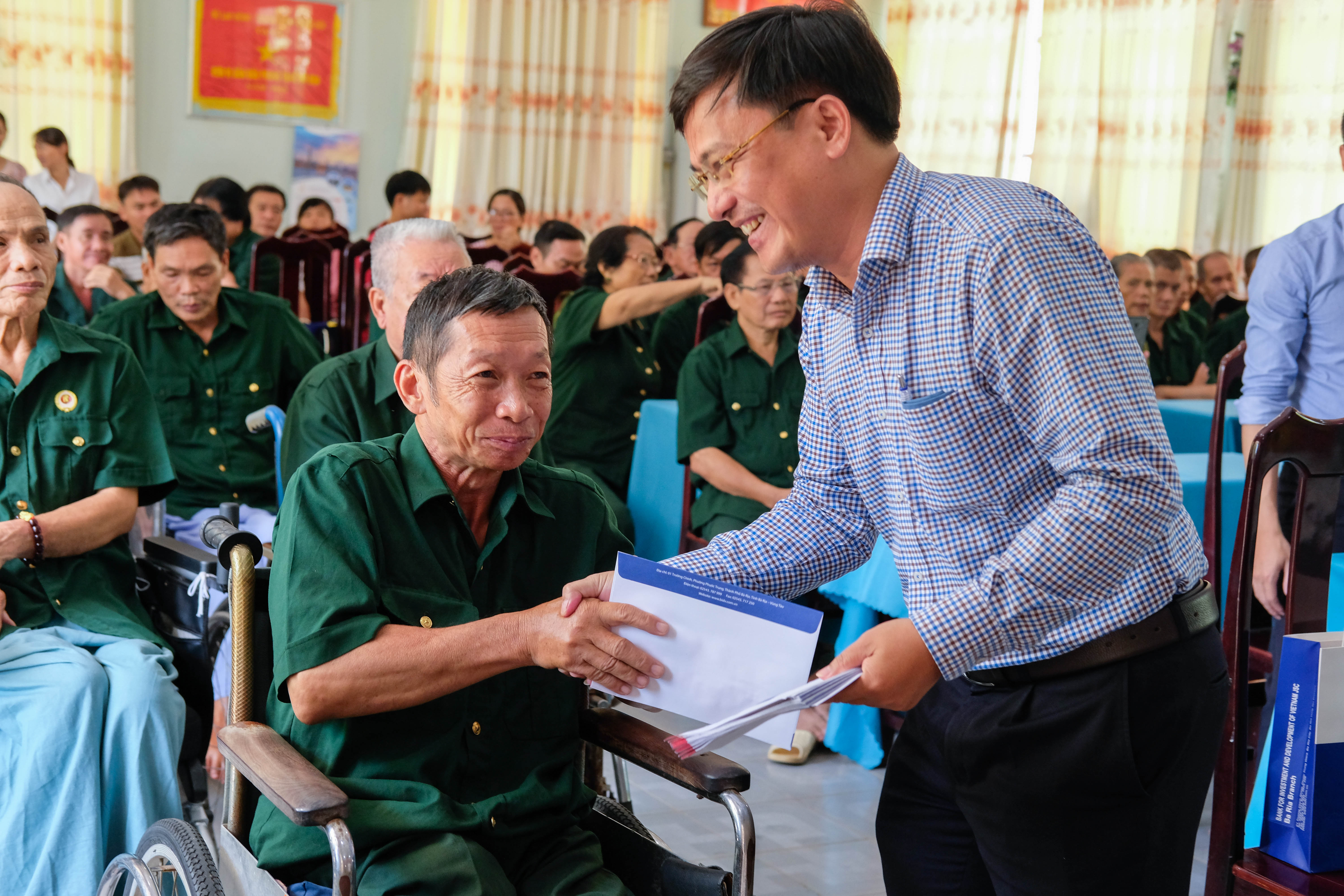 Ông Trần Văn Nhân, Chủ tịch Công đoàn cơ sở, Phó Giám đốc BIDV, Chi nhánh Bà Rịa trao quà cho các thương binh và người có công tại trung tâm điều dưỡng Long Đất. Ảnh: THU THẢO