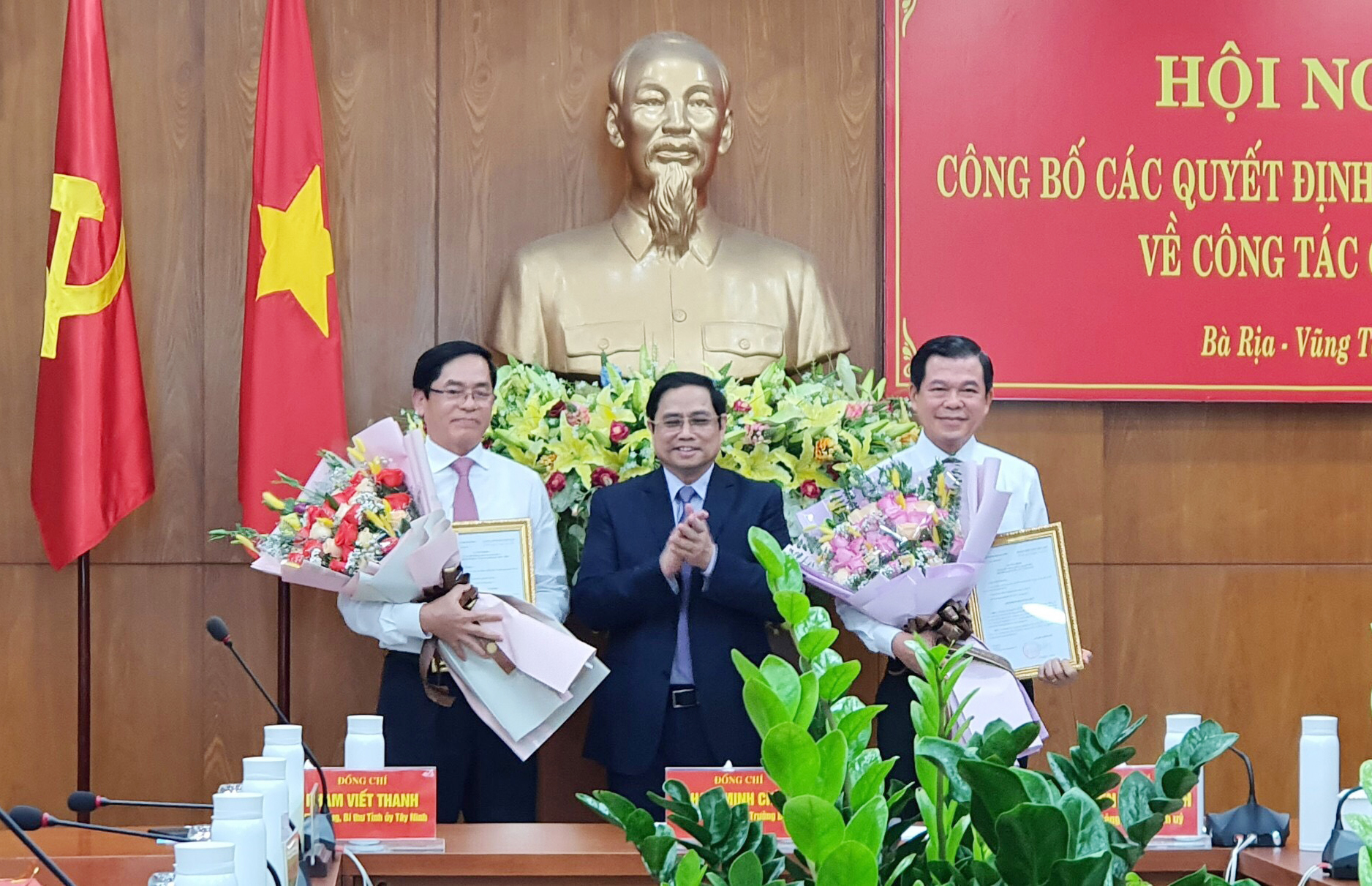 Đồng chí Phạm Minh Chính, Ủy viên Bộ Chính trị, Trưởng Ban Tổ chức Trung ương, trao các Quyết định cho đồng chí Phạm Viết Thanh (bìa trái) và đồng chí Nguyễn Hồng Lĩnh (bìa phải).