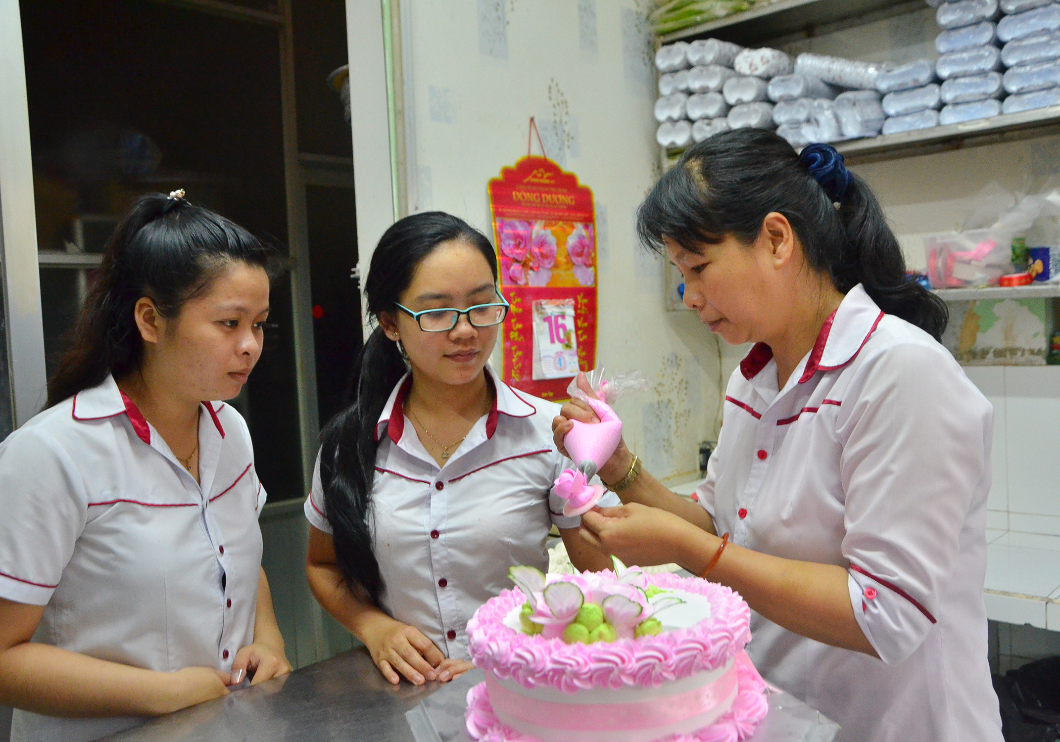 Tiệm bánh Ngọc Hải là cơ sở đầu tiên tham gia mô hình “Phụ nữ cam kết sản xuất thực phẩm an toàn” do Hội LHPN tỉnh triển khai. Trong ảnh: Chị Ngọc Ngân (phải), chủ tiệm bánh Ngọc Hải hướng dẫn nhân viên hoàn thiện bánh kem.