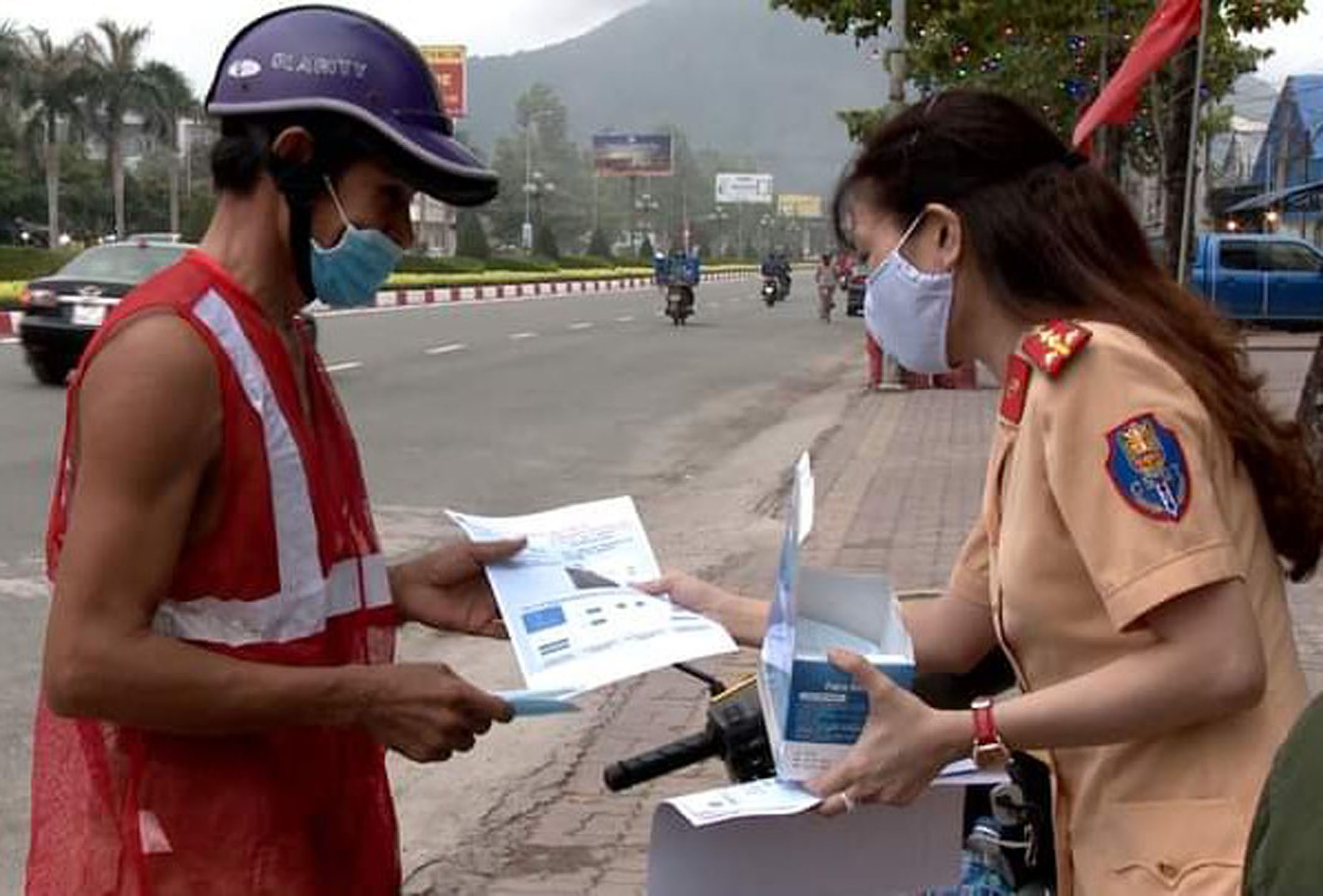 CSGT TX.Phú Mỹ phát khẩu trang và tờ rơi tuyên truyền cài đặt Bluezone cho người tham gia giao thông tại đường  Trần Hưng Đạo, TX.Phú Mỹ. Ảnh: VĂN ANH