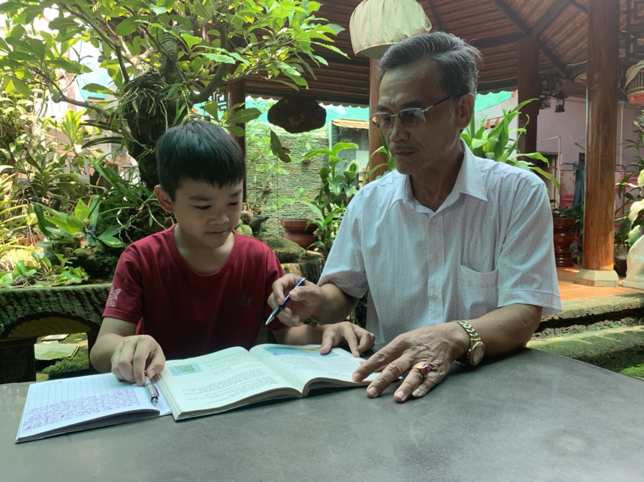 Ông Phạm Văn Khánh, trưởng dòng họ Phạm hướng dẫn cháu trai học bài.