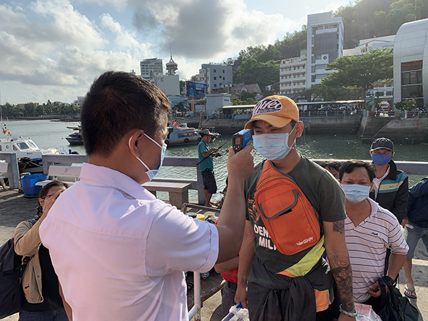 Nhân viên Công ty CP Tàu cao tốc Phú Quốc kiểm tra thân nhiệt của hành khách trước khi tàu khởi hành ra huyện Côn Đảo.