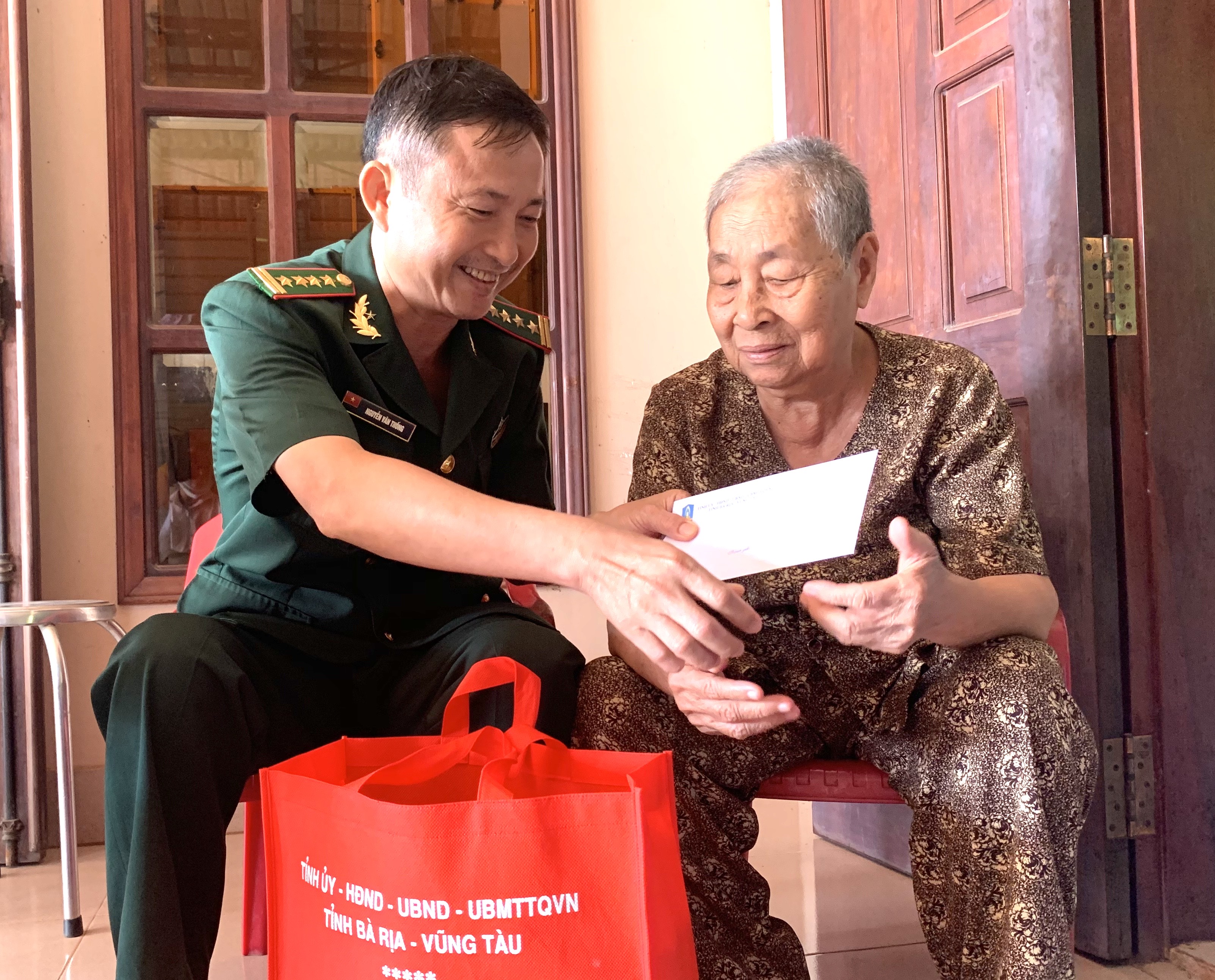 Đại tá Nguyễn Văn Thống, Phó Chính uỷ Bộ Chỉ huy BĐBP tỉnh thăm, tặng quà bà Phan Thị Mười, con liệt sĩ Phan Văn Biểu (xã Bàu Lâm, huyện Xuyên Mộc). Ảnh: MINH NHÂN