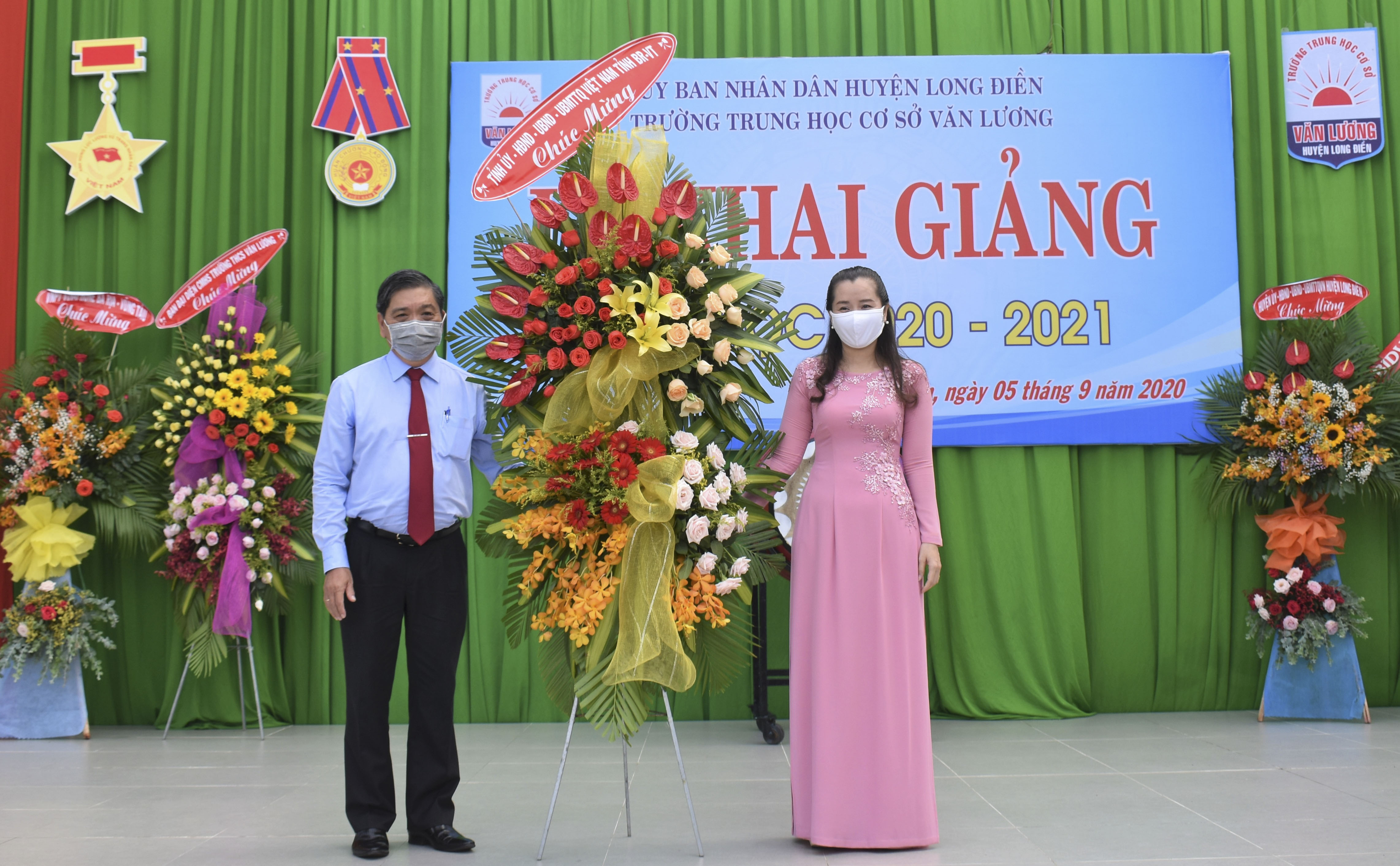 Ông Lê Tuấn Quốc, Phó Chủ tịch UBND tỉnh tặng hoa chúc mừng thầy và trò Trường THCS Văn Lương (huyện Long Điền). ẢNH: PHI DŨNG