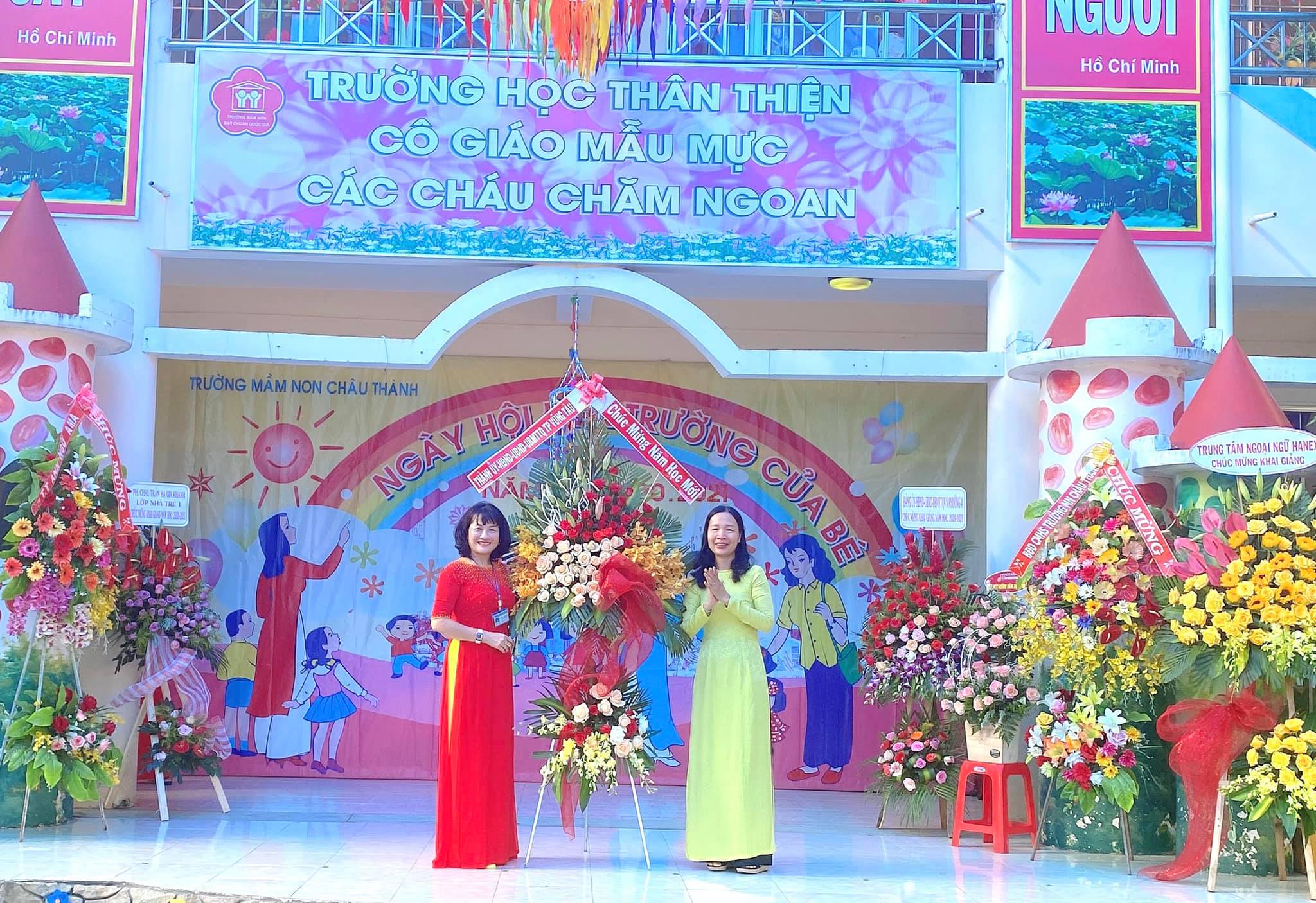 Đại diện Thành ủy - HĐND - UBND – UBMTTQ Việt Nam TP. Vũng Tàu (phải) tặng hoa chúc mừng thầy và trò Trường MN Châu Thành (TP. Vũng Tàu). Ảnh: KHÁNH CHI