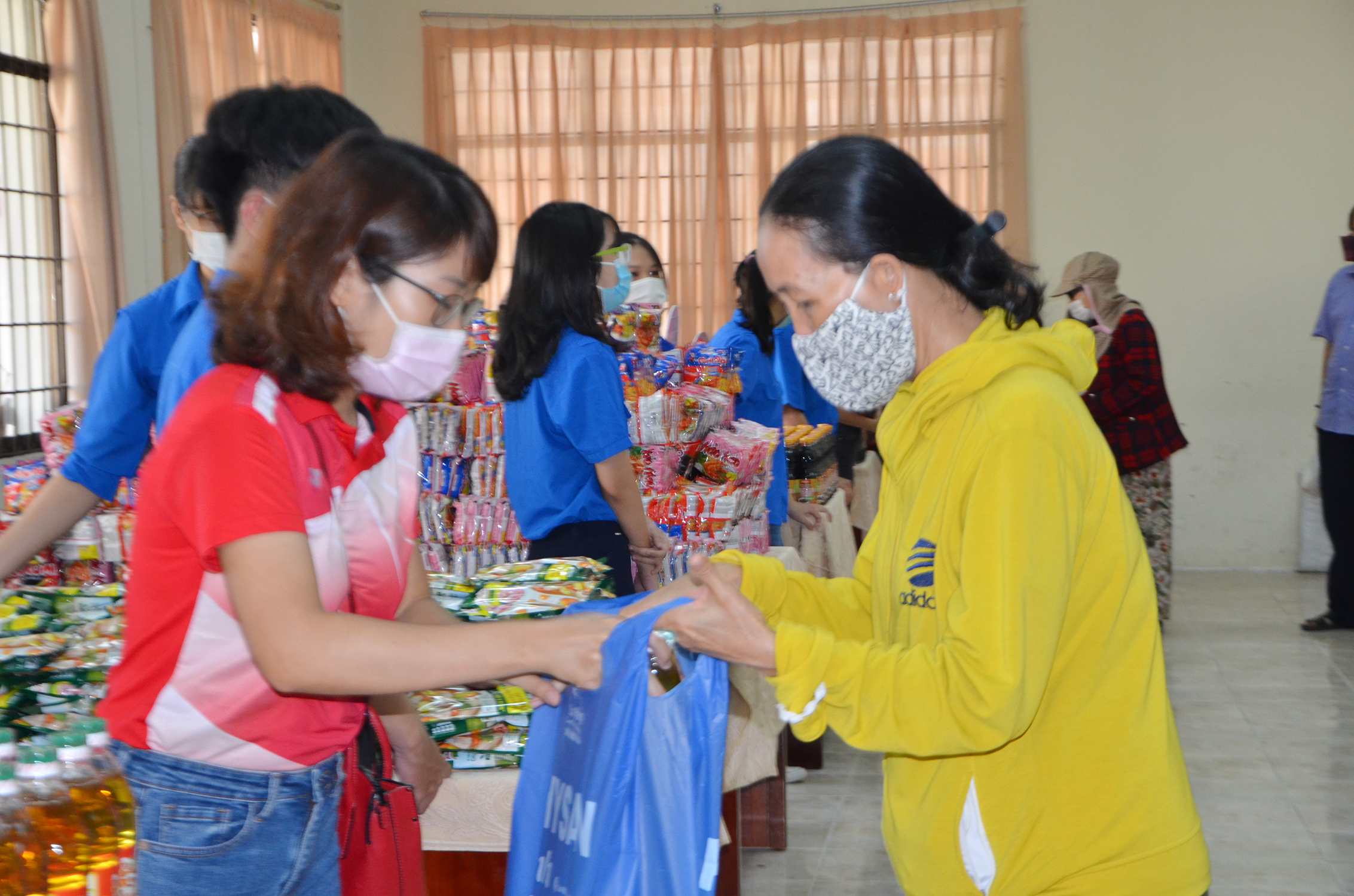 Người dân khi đến “Siêu thị 0 đồng” được các ĐVTN hướng dẫn đeo khẩu trang, sát khuẩn và giãn cách 2m, nhằm phòng, chống COVID-19.