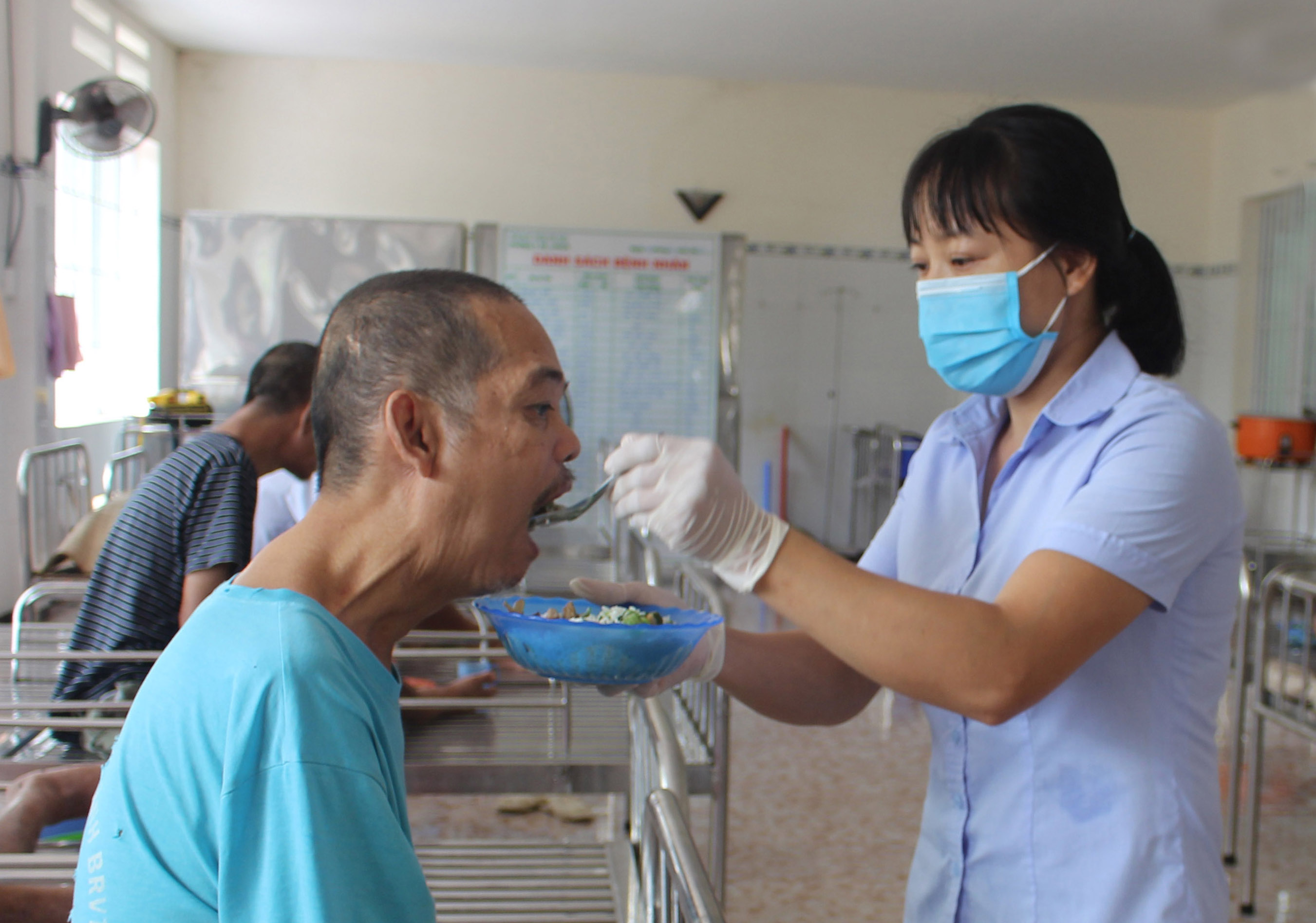 Chị Nguyễn Thị Ngát cẩn thận đút từng muỗng cơm cho các đối tượng đang sinh sống ở TTXH tỉnh.
