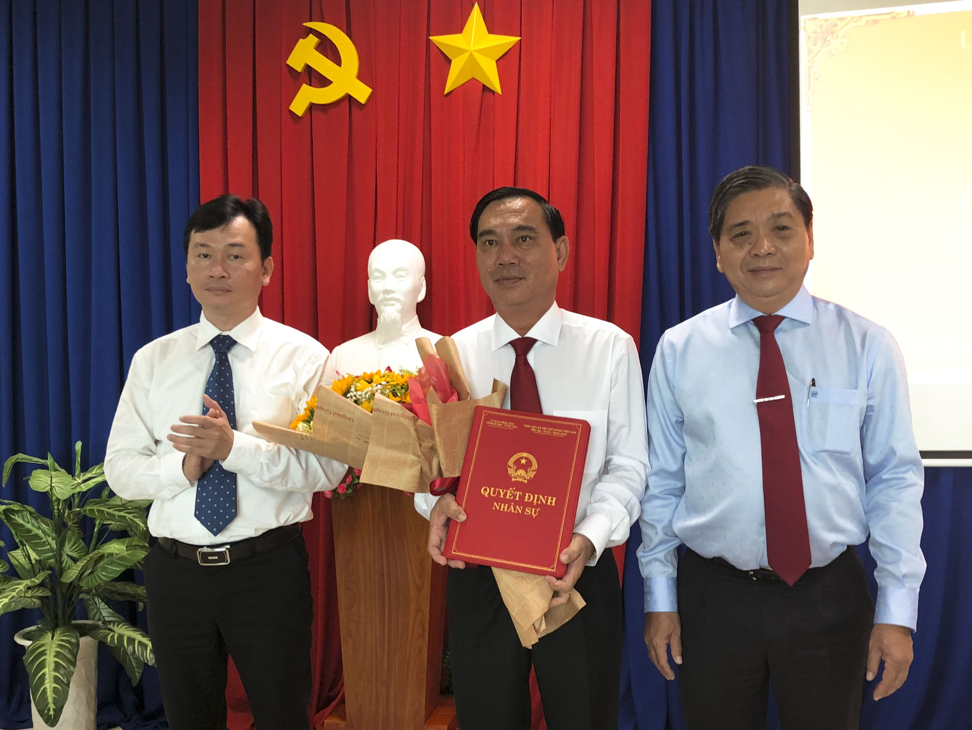 Ông Lê Tuấn Quốc, Phó Chủ tịch UBND tỉnh (bìa phải) và ông Phạm Thành Chung, Bí thư Đảng ủy Khối Cơ quan và DN tỉnh (bìa trái) trao Quyết định bổ nhiệm và tặng hoa chúc mừng ông Nguyễn Văn Đa.