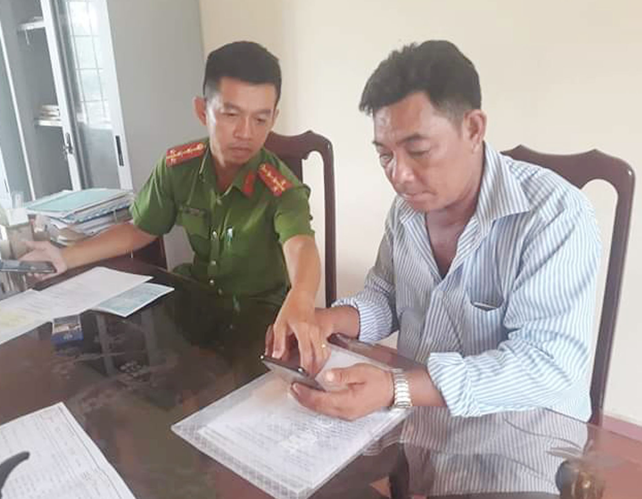 An ninh trật tự tại thị trấn Đất Đỏ ngày càng tốt hơn nhờ sự chung tay của người dân trong phong trào toàn dân bảo vệ ANTQ. Trong ảnh: Công an huyện Đất Đỏ hướng dẫn người dân cài đặt mô hình “Kết nối toàn dân-bình yên cuộc sống” trên Zalo. 