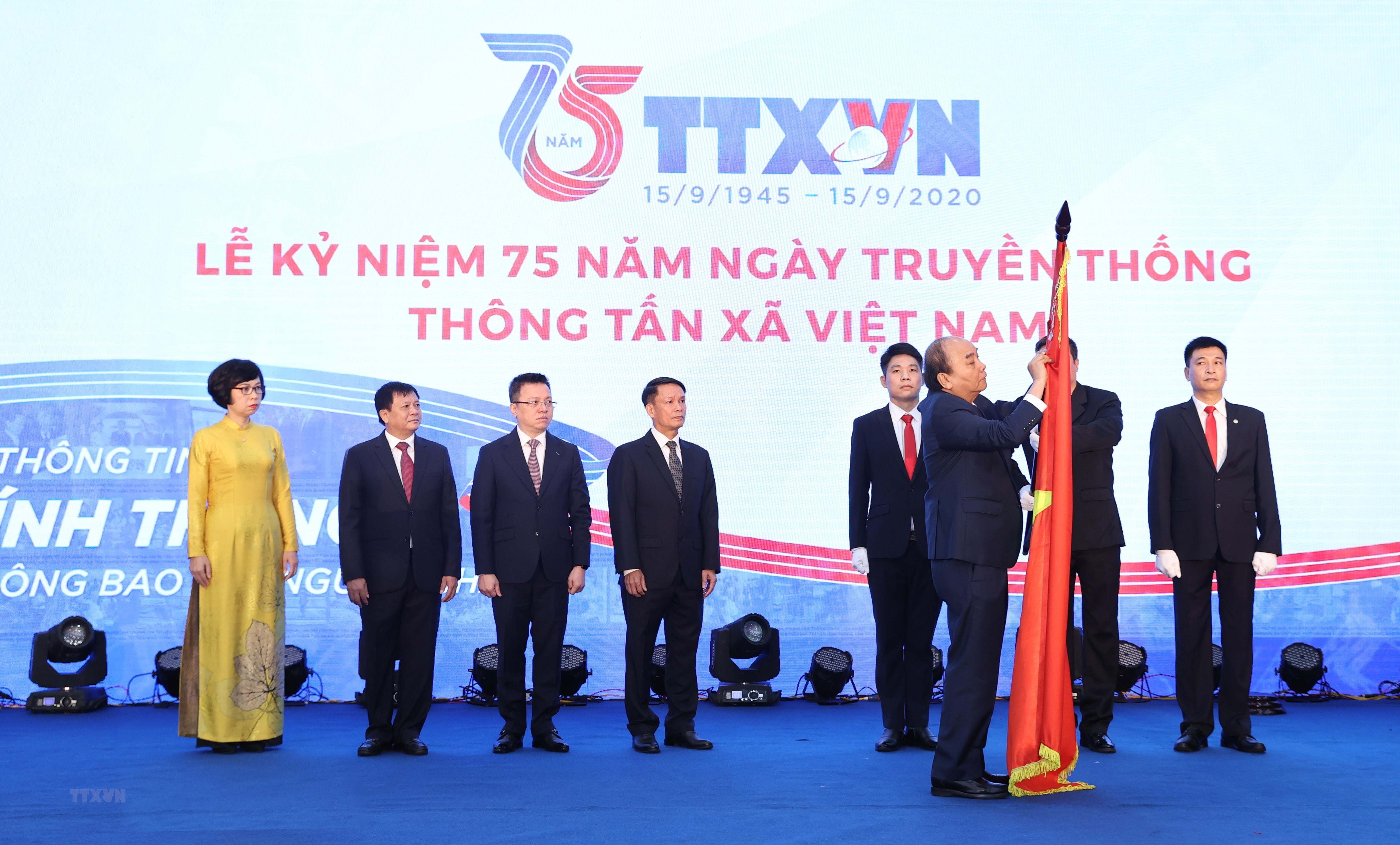 Thủ tướng Nguyễn Xuân Phúc gắn Huân chương Lao động hạng Nhất lên lá cờ truyền thống của Thông tấn xã Việt Nam.