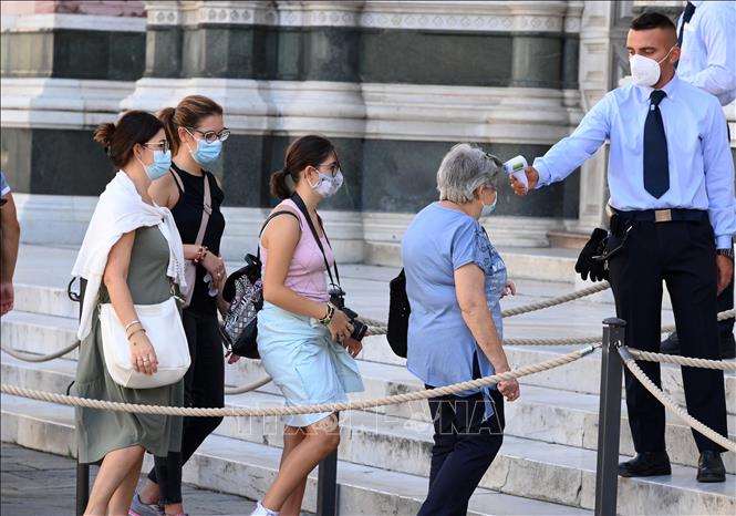 Kiểm tra thân nhiệt nhằm phòng ngừa dịch COVID-19 tại Florence, Italy.  Ảnh: THX/TTXVN