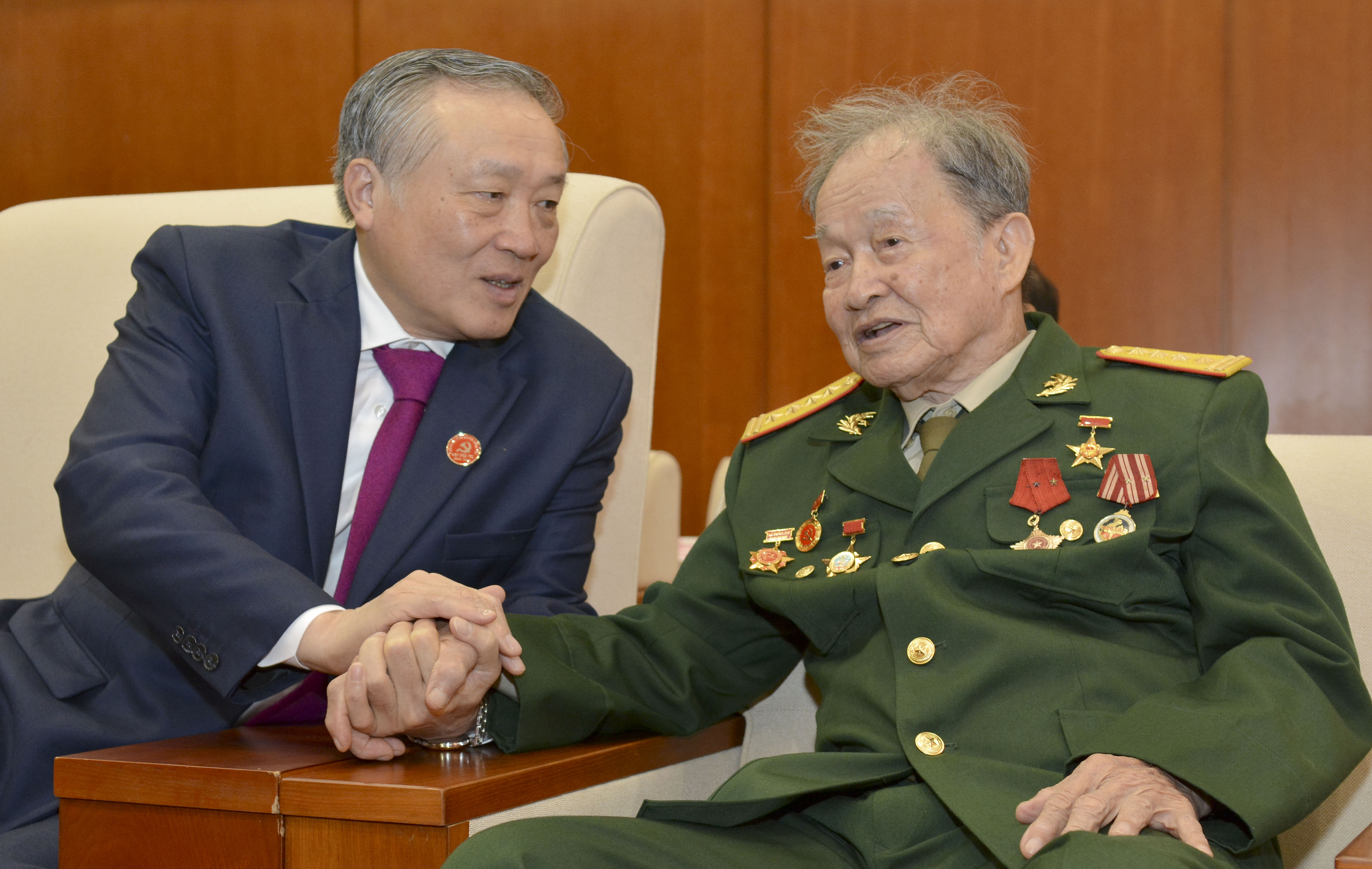 Đồng chí Nguyễn Hòa Bình, Bí thư Trung ương Đảng, Chánh án Tòa án Nhân dân Tối cao thăm hỏi Đại tá, Anh hùng LLVTND Nguyễn Văn Tàu nhân dịp về dự Đại hội.