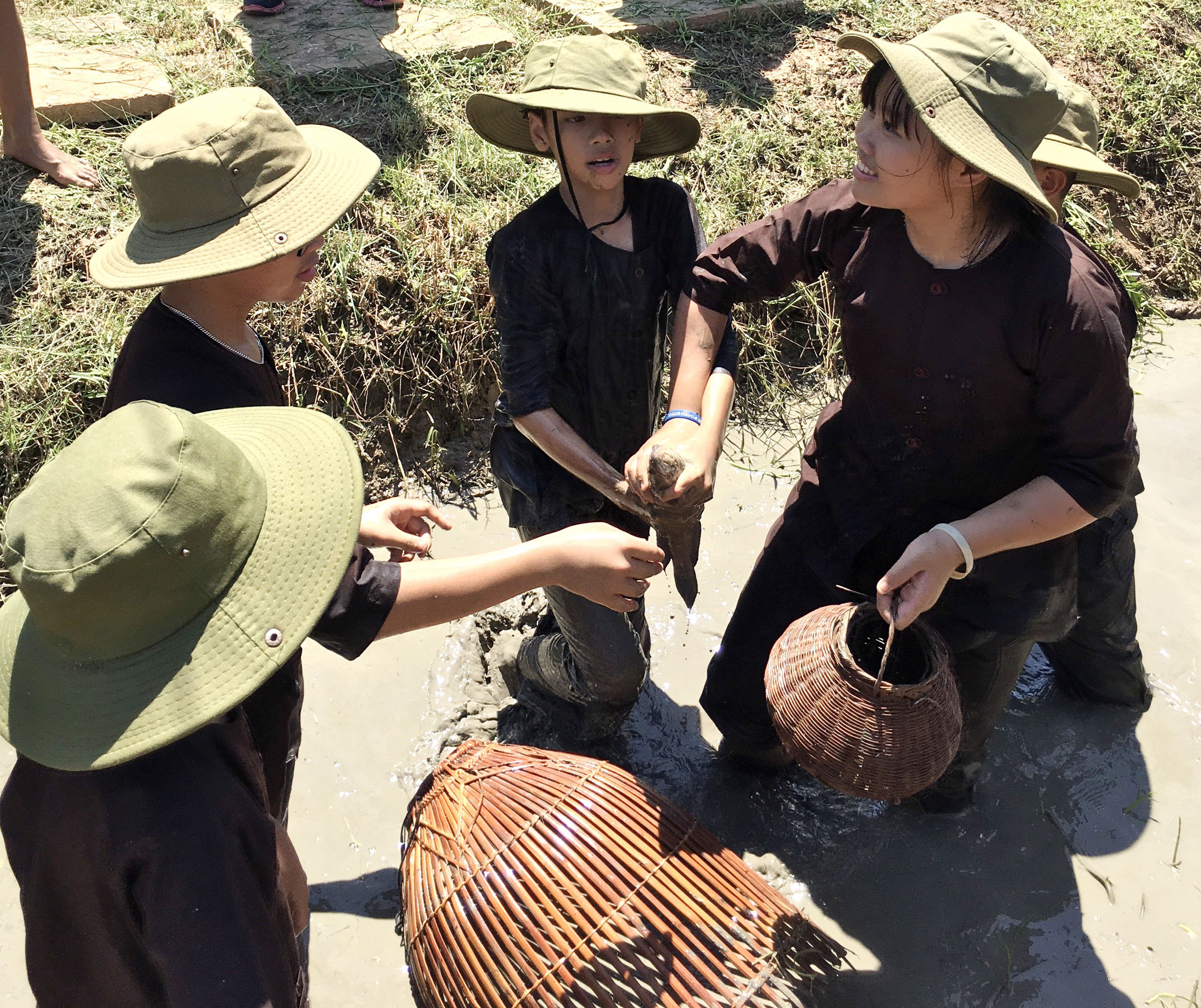 Các em thích thú khi tự tay bắt cá dưới mương.