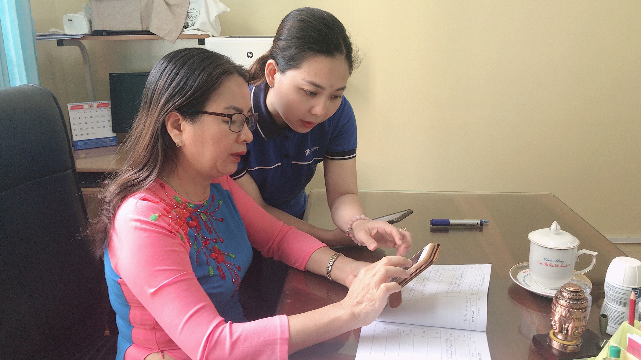 Nhân viên VNPT BR-VT hỗ trợ Hiệu trưởng trường THCS Phước Thắng sử dụng một số ứng dụng mới của vnEdu trên điện thoại.
