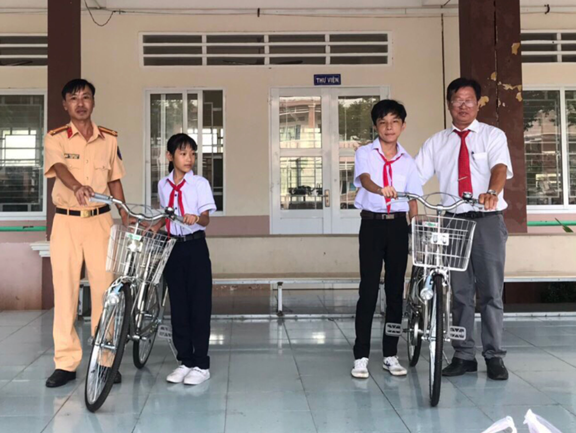 Đại diện Đội CSGT - Công an huyện Long Điền tặng xe đạp cho HS. Ảnh: VĂN ANH