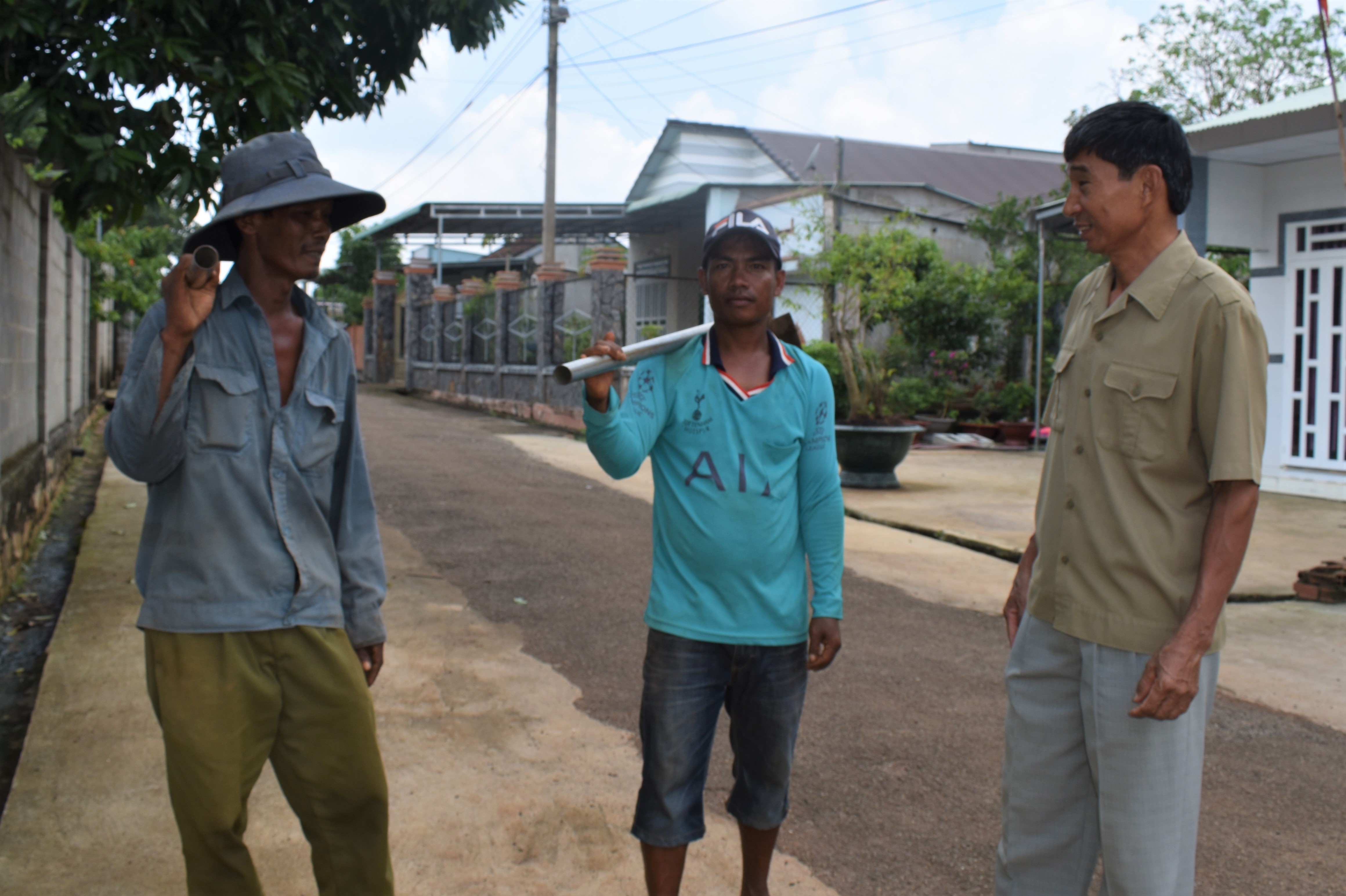 CCB Nguyễn Văn Diên (bìa phải) trò chuyện cùng người dân trên con đường nông thôn tại tổ 75 đã được nâng cấp, mở rộng.