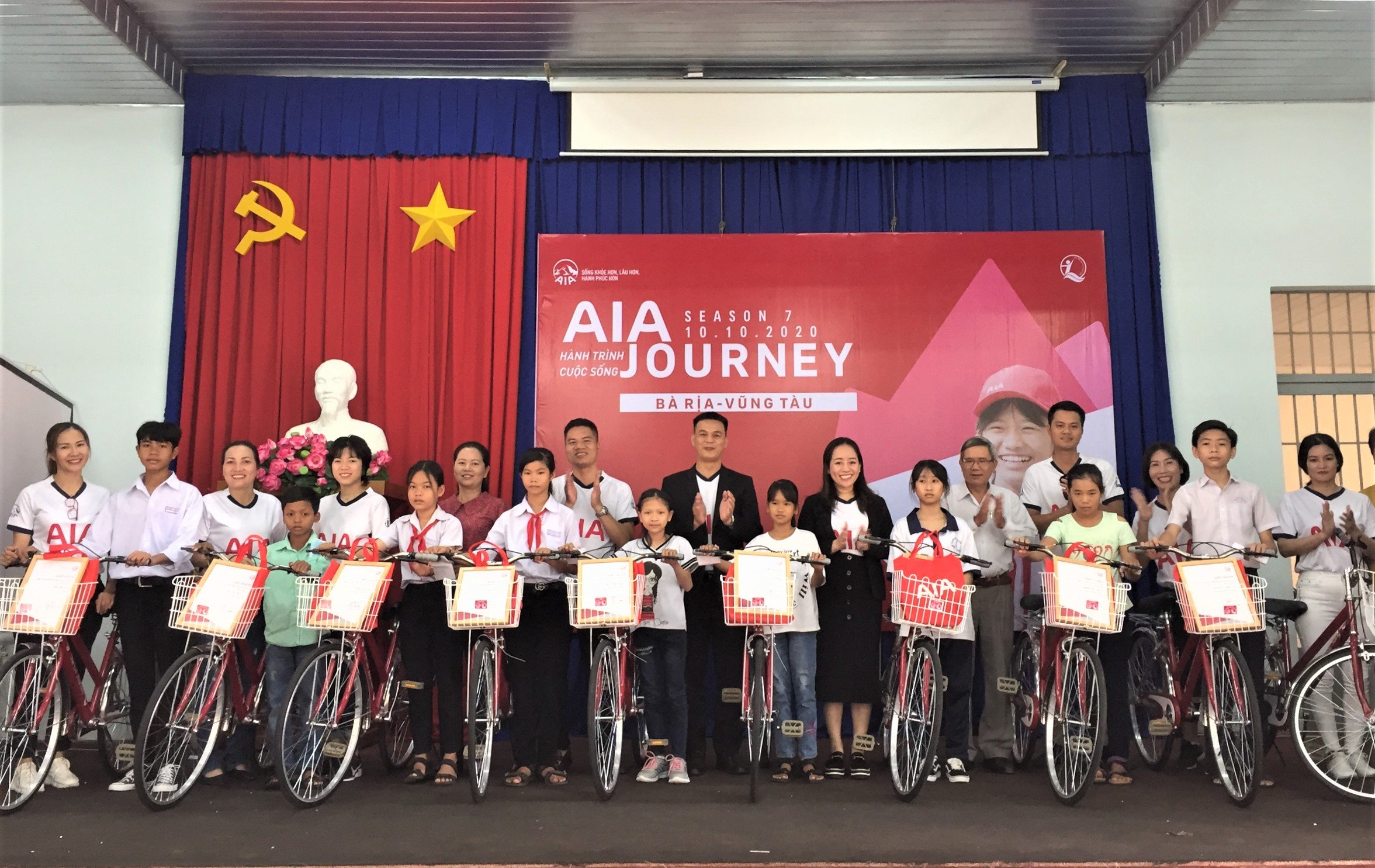 Đại diện Công ty Bảo hiểm nhân thọ AIA Việt Nam và chính quyền địa phương trao xe đạp cho HS nghèo trong chương trình.