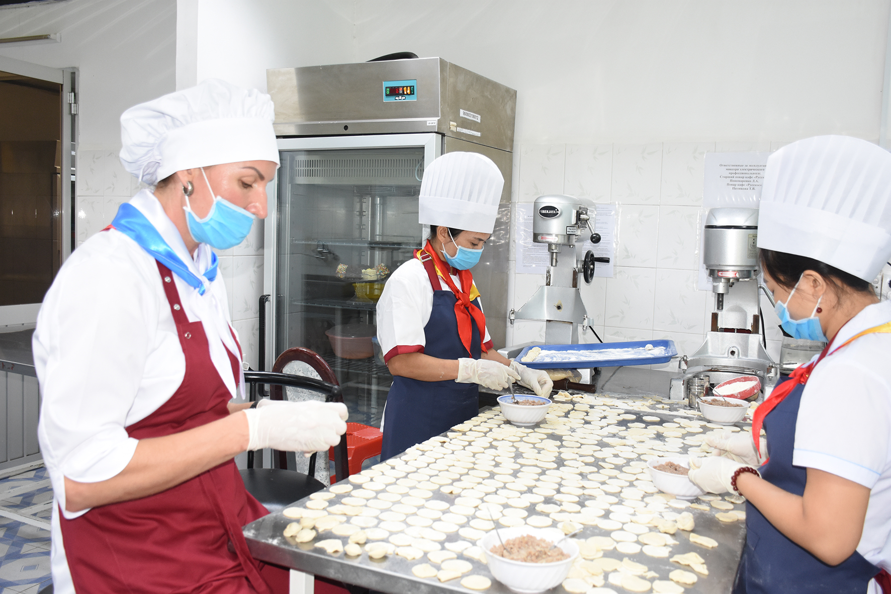 Những công nhân người Nga và người Việt đang thực hiện những công đoạn sản xuất bánh mì tại lò bánh mì trong làng Nga.