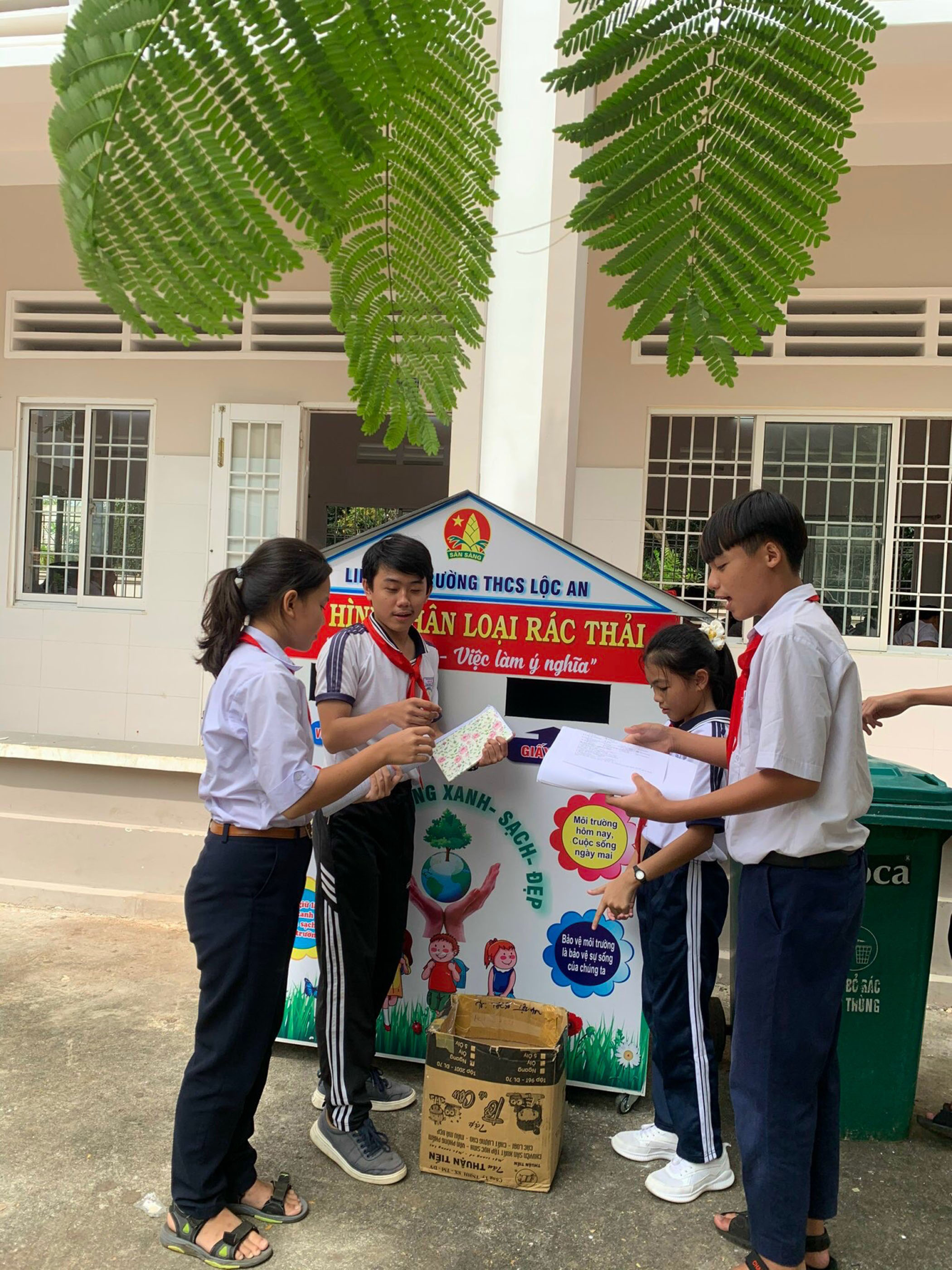 Học sinh Trường THCS Lộc An phân loại rác trước khi bỏ vào thùng.