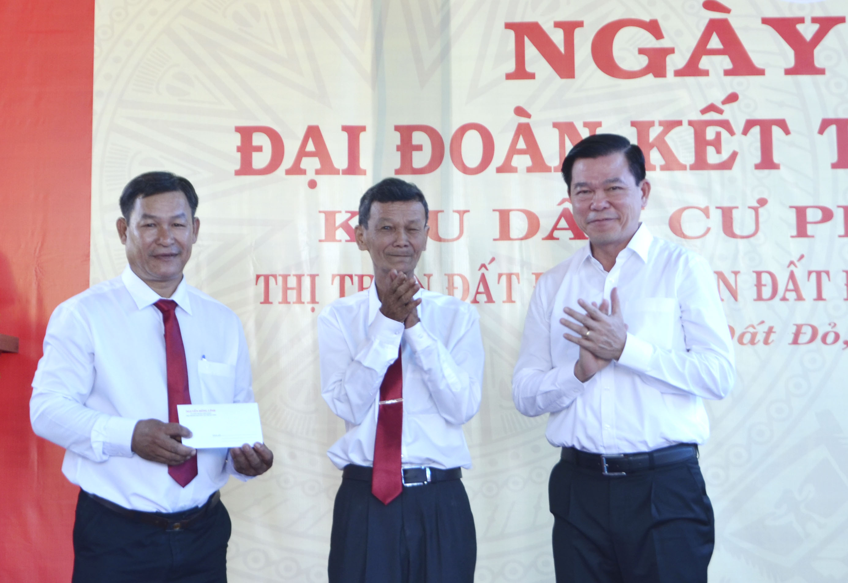 Ông Nguyễn Hồng Lĩnh (bìa phải), Ủy viên Trung ương Đảng, Phó Trưởng Ban Dân vận Trung ương trao quà cho đại diện KP. Phước Trung, TT. Đất Đỏ.
