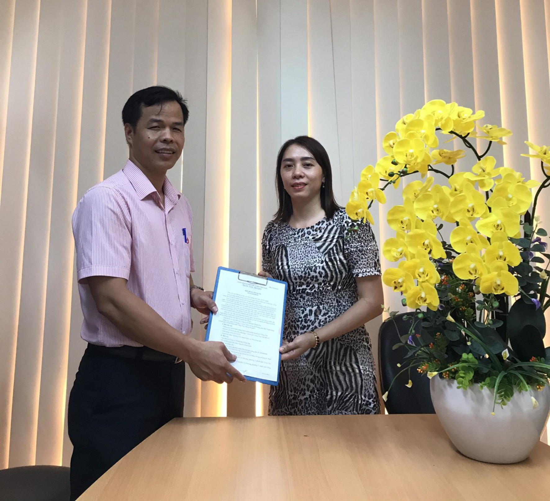Ông Trương Văn Mười, Phó Giám đốc Phòng giao dịch NHCSXH TP. Vũng Tàu trao hợp đồng tín dụng cho đại diện  Công ty TNHH Thành Đạt.