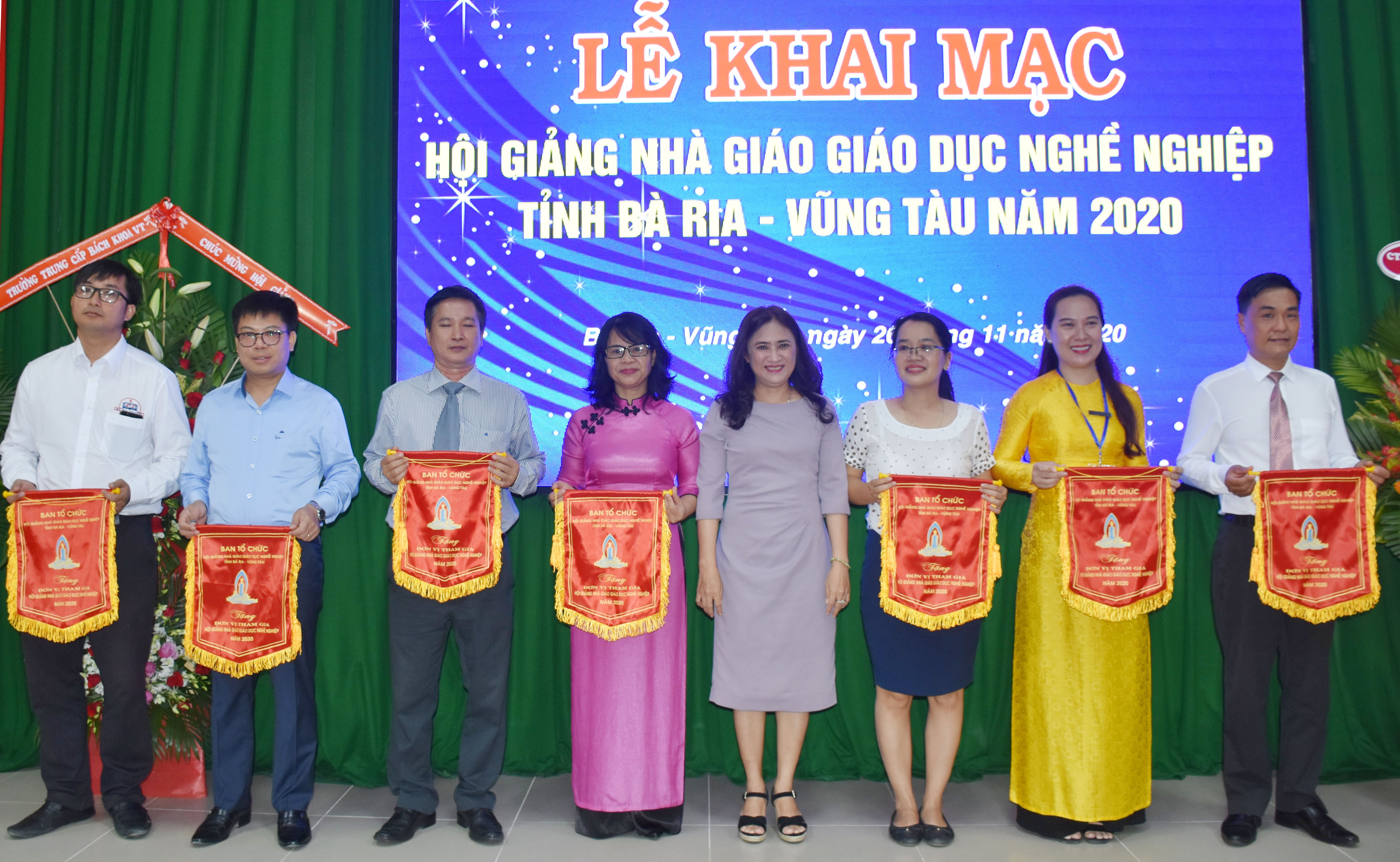 Bà Đinh Thị Trúc My, Phó Giám đốc Sở LĐTBXH trao cờ lưu niệm cho các cơ sở giáo dục nghề nghiệp tham gia hội thi.