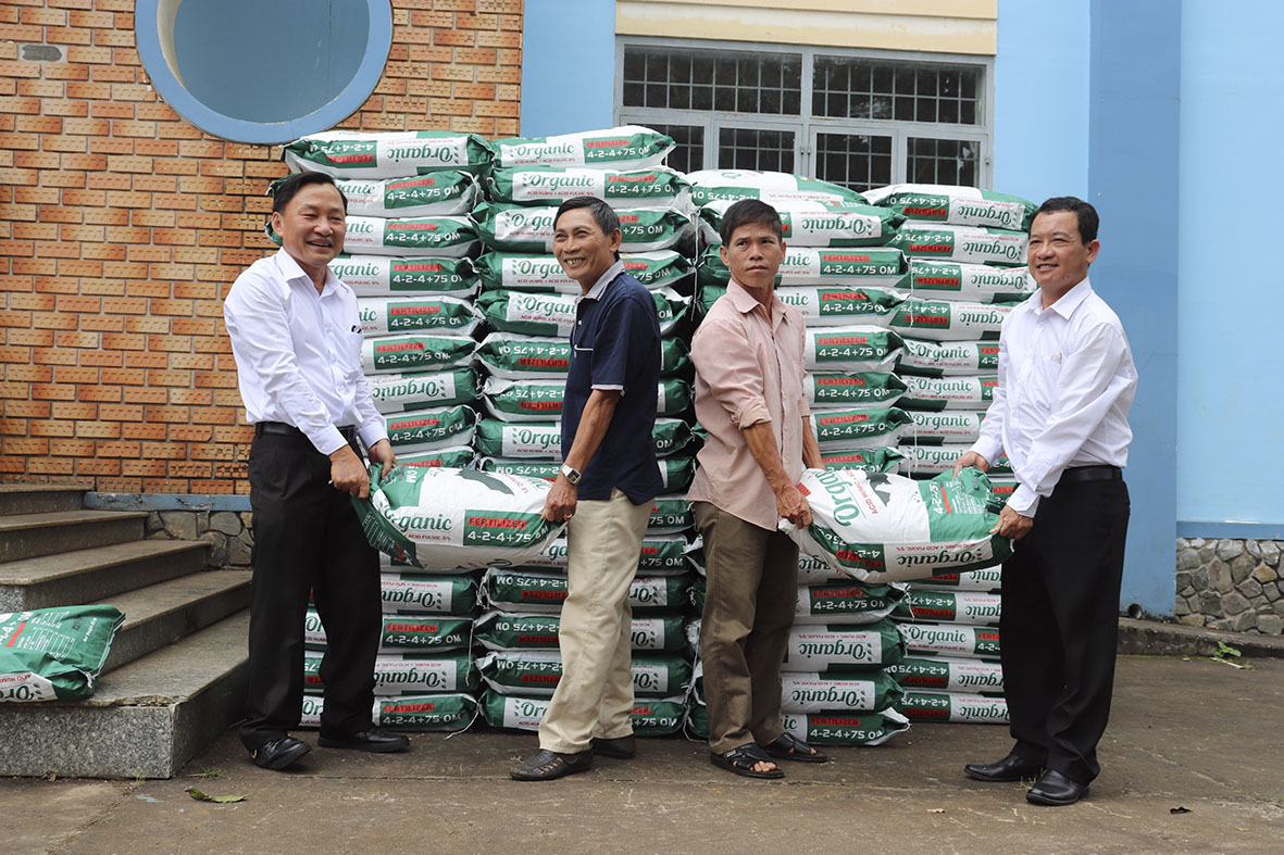 Ông Nguyễn Đạo Cứ (bìa phải), Trưởng Ban Kinh tế - Xã hội (Hội Nông dân tỉnh), Phó Giám đốc Qũy Hỗ trợ Nông dân tỉnh bàn giao phân bón cho nông dân xã Xà Bang.