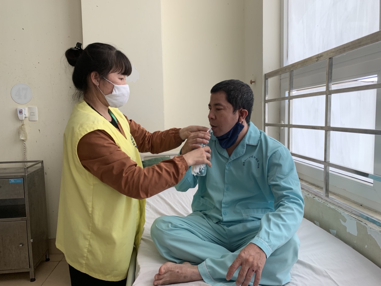 Chị Ngô Thị Ngọc (43 tuổi, ngụ xã Nghĩa Thành, huyện Châu Đức)  chăm sóc chồng nằm điều trị tại Khoa Tim mạch (BV Bà Rịa).
