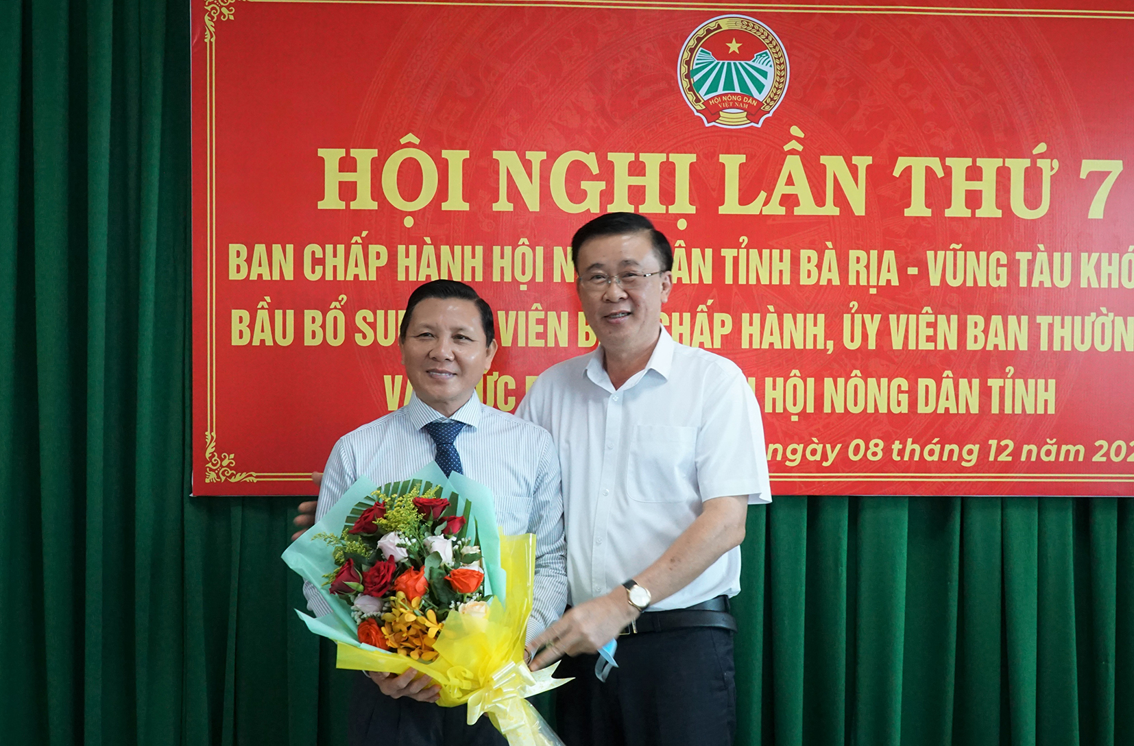 Ông Huỳnh Văn Danh, Ủy viên Ban Thường vụ, Trưởng Ban Dân vận Tỉnh ủy (phải) tặng hoa chúc mừng ông Mai Minh Quang.