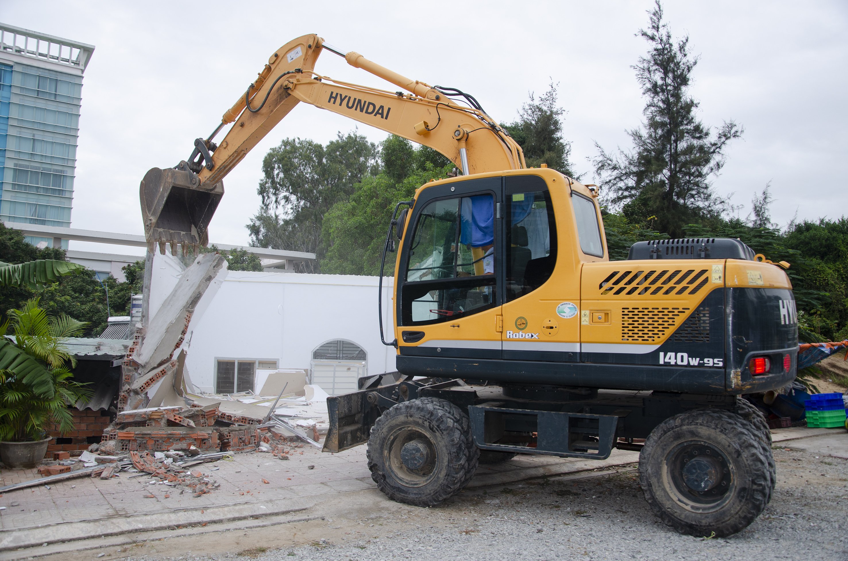Xe cuốc của lực lượng chức năng tháo dỡ các hạng mục trong công trình vi phạm.
