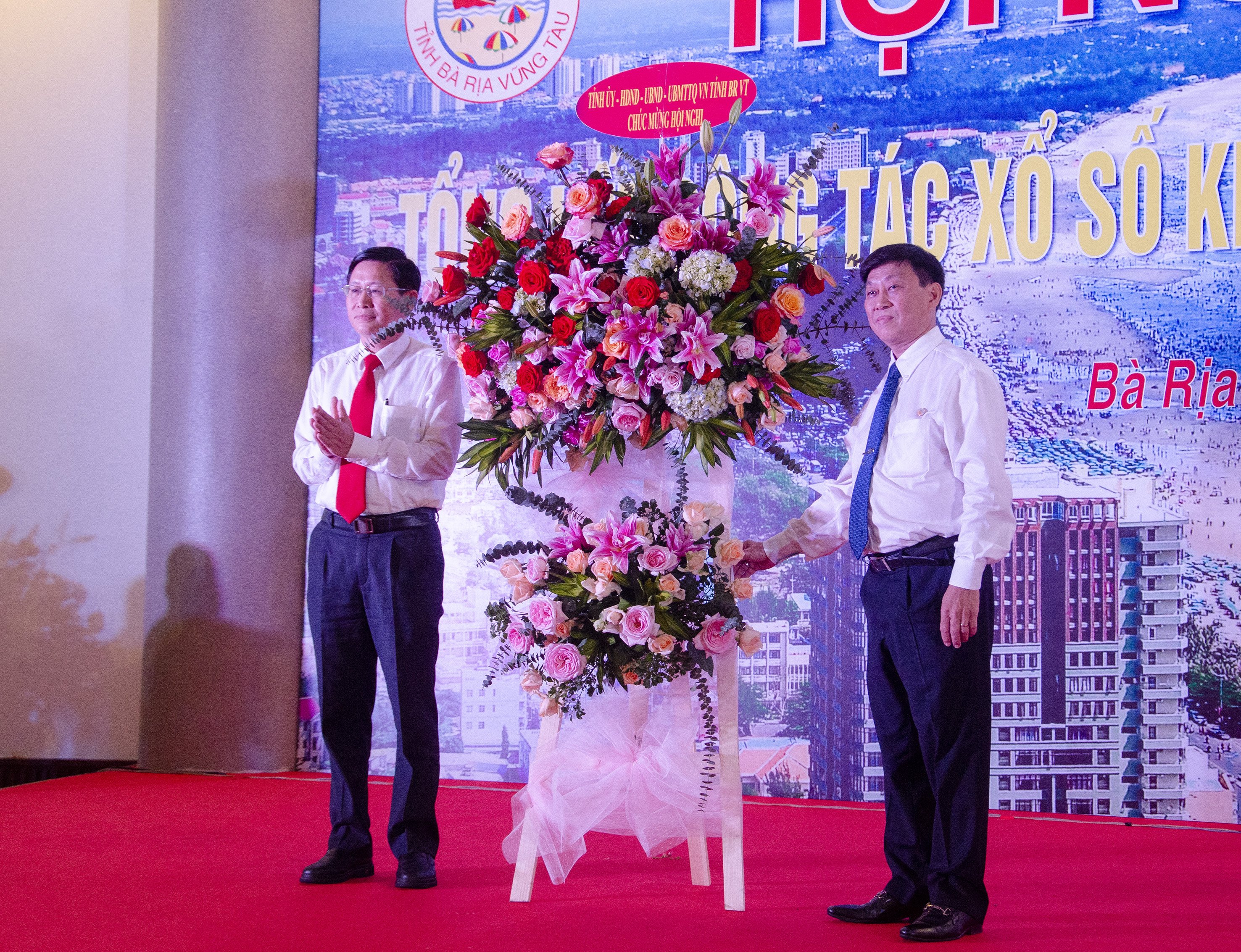 Ông Lê Ngọc Khánh (trái), Phó Chủ tịch UBND tỉnh, Chủ tịch Hội đồng giám sát XSKT tỉnh tặng hoa chúc mừng Công ty TNHH MTV XSKT tỉnh.