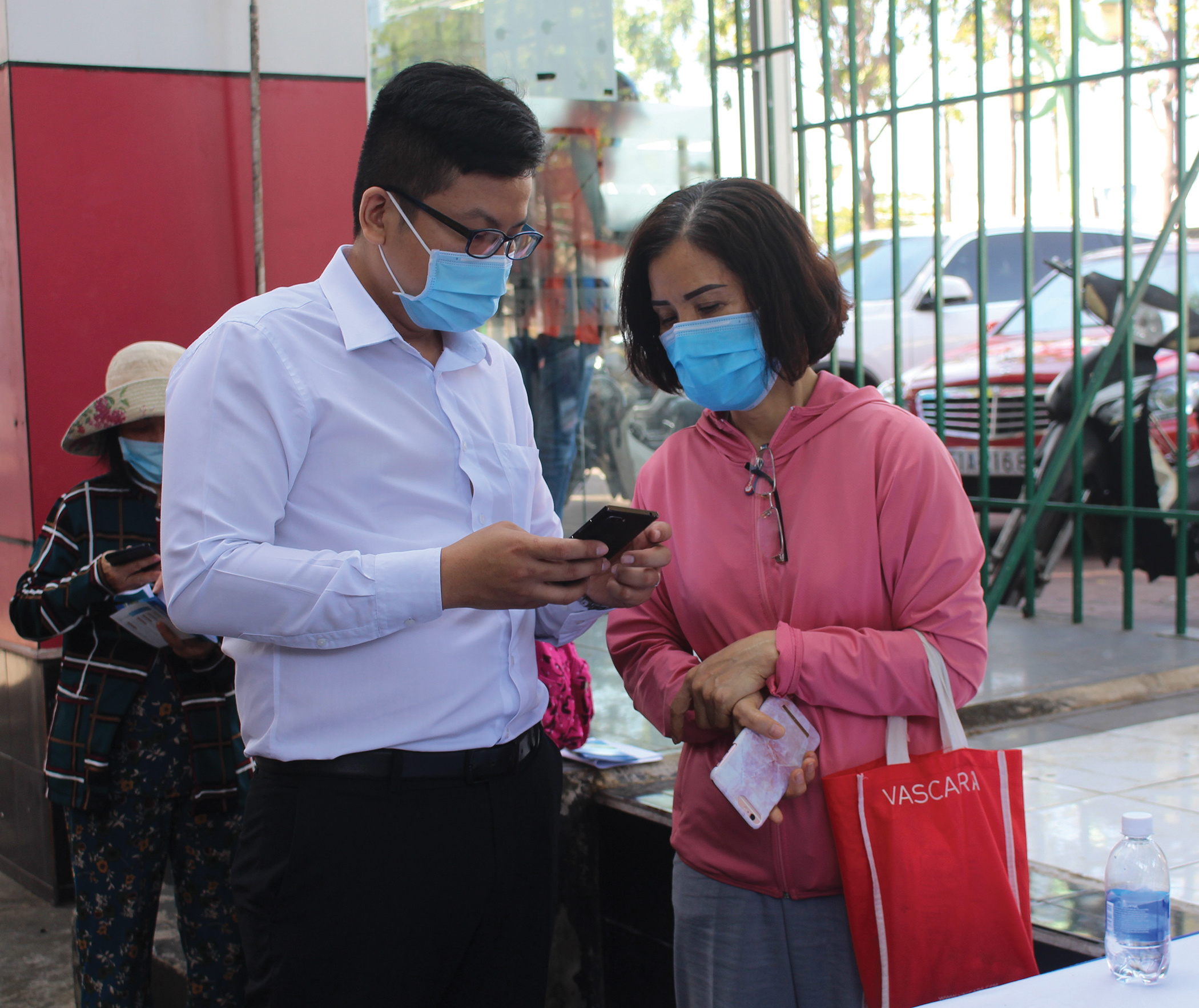 Nhân viên của đơn vị cung cấp giải pháp đăng ký khám trực tuyến Medpro cho Bệnh viện Lê Lợi hướng dẫn người dân cài đặt ứng dụng trên điện thoại thông minh.