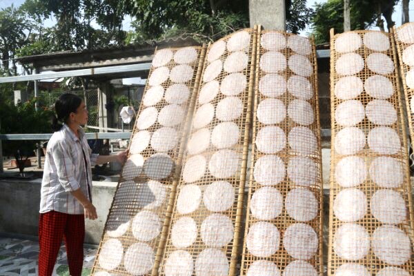 Bà Trương Thị Mỹ Hạnh (ấp An Hòa, xã An Ngãi, huyện Long Điền) phơi những liếp bánh đầu tiên trong ngày.
