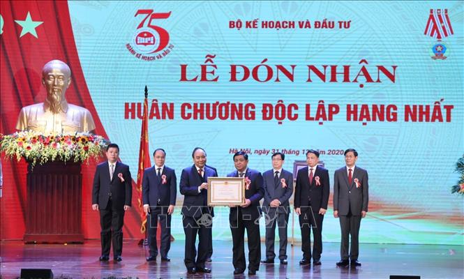 Thủ tướng Nguyễn Xuân Phúc, Chủ tịch Hội đồng Thi đua-Khen thưởng Trung ương tặng Huân chương Lao động hạng Nhất cho Bộ trưởng Bộ Kế hoạch và Đầu tư Nguyễn Chí Dũng. Ảnh: Danh Lam/TTXVN