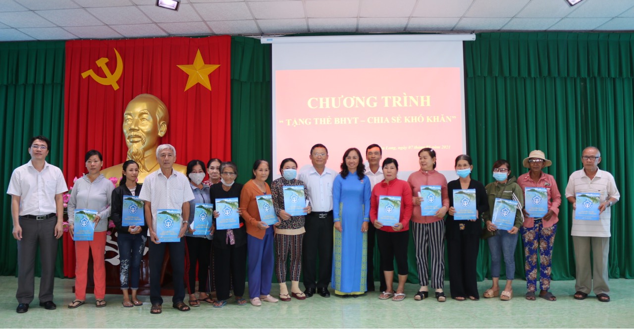 Ông Đặng Hồng Tuấn (thứ 9, từ phải qua), Phó Giám đốc BHXH tỉnh tặng thẻ BHYT cho người dân xã Hòa Long.
