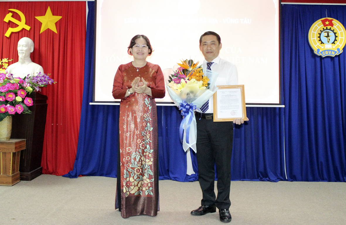 Bà Nguyễn Thị Yến, Phó Bí thư Thường trực Tỉnh ủy, Trưởng Đoàn ĐBQH tỉnh trao Quyết định và tặng hoa chúc mừng ông Huỳnh Sơn Tuấn giữ chức Chủ tịch LĐLĐ tỉnh.