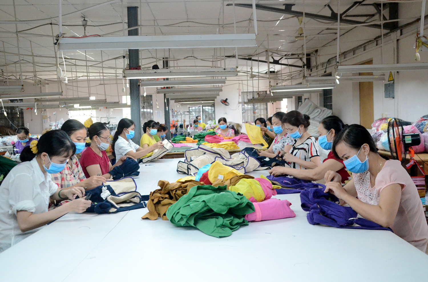 Dịp Tết Tân Sửu 2021, người lao động trong DN được nghỉ 5 ngày. Để kéo dài kỳ nghỉ, người lao động  có thể xin nghỉ phép năm hoặc xin nghỉ không lương. Trong ảnh: Các nữ công nhân may ba lô xuất khẩu  tại Công ty May Thăng Long. Ảnh: ĐÔNG HIẾU