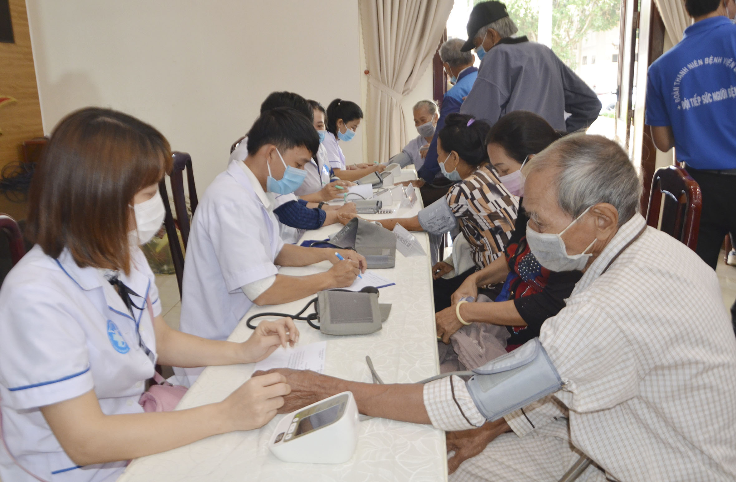 Nhân viên y tá đo huyết áp cho người dân. 