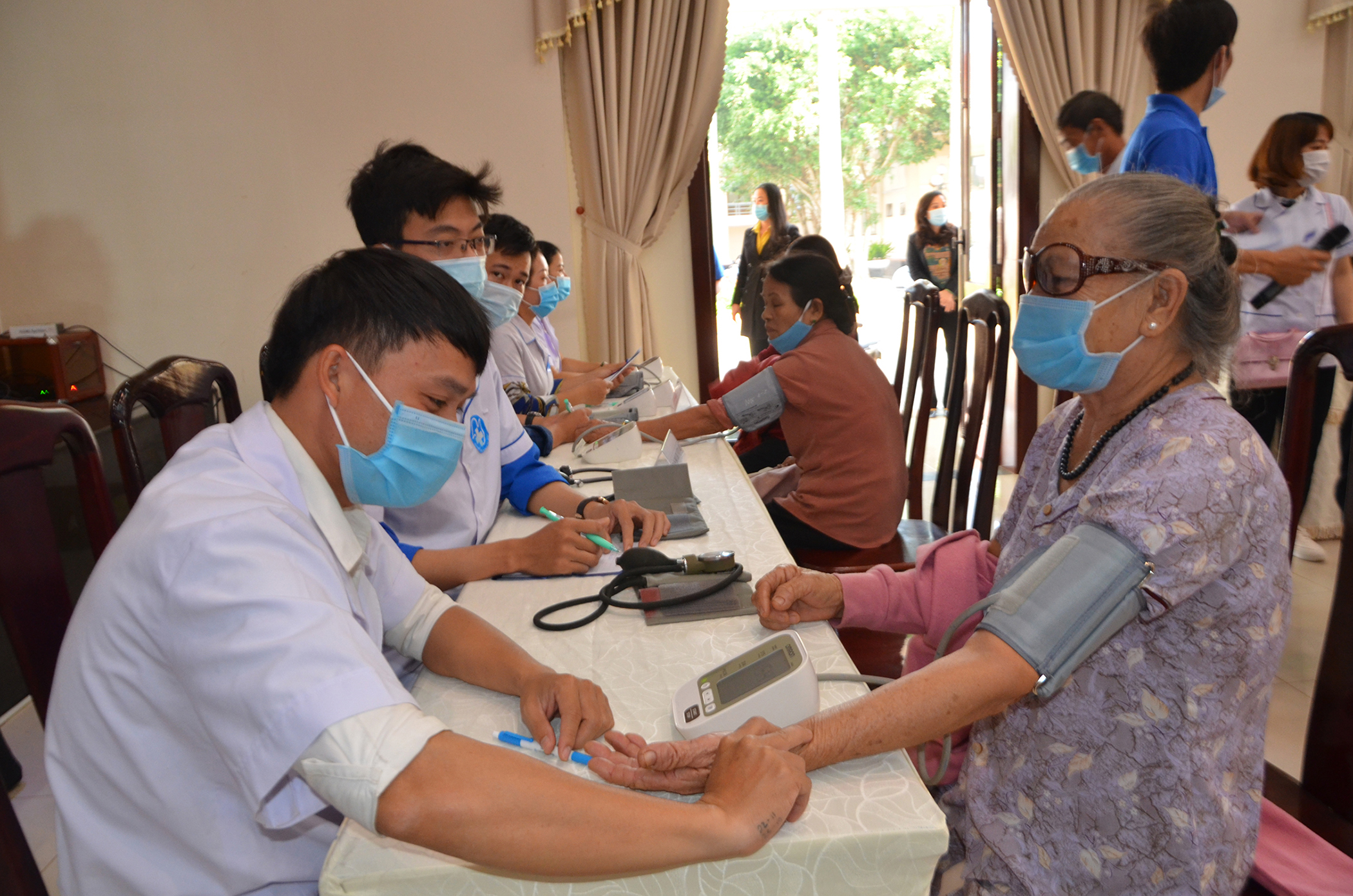 Y tá Nguyễn Đăng Quang (Trung tâm Y tế huyện Châu Đức) đo huyết áp và tư vấn cho người bệnh.