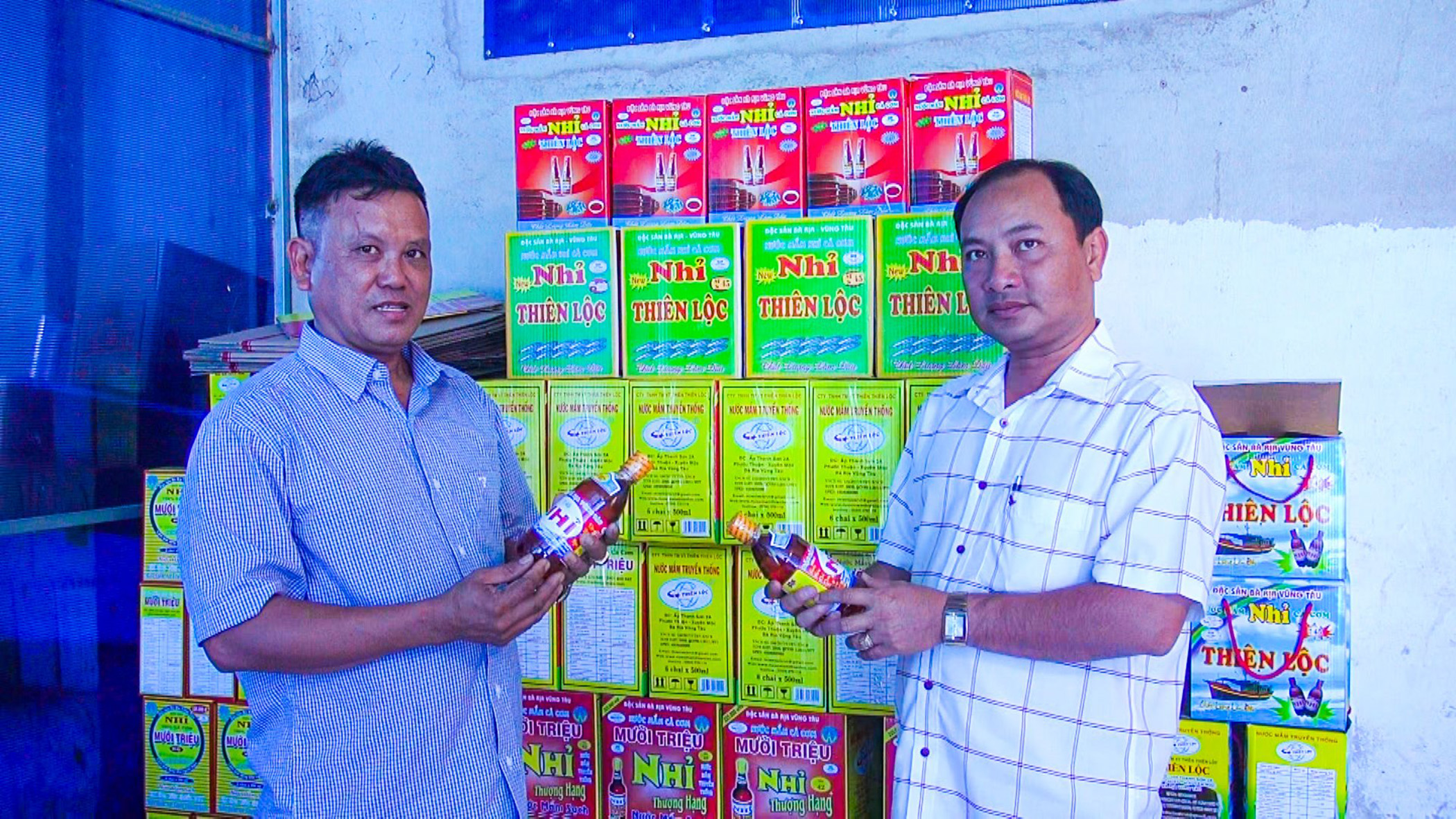 Ông Nguyễn Cao Thiên (bìa trái), giới thiệu sản phẩm nước mắm nhỉ Thiên Lộc với ông Bùi Đình Nam, Phó Ban Kinh tế - Ngân sách, Phó Giám đốc Quỹ Hỗ trợ nông dân tỉnh (Hội Nông dân tỉnh).