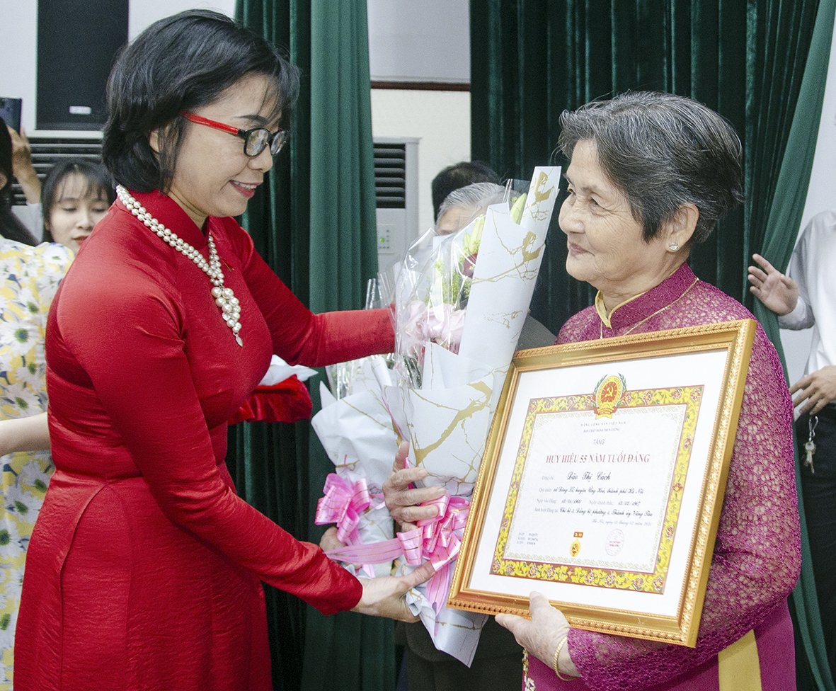 Bà Lê Thị Thanh Bình, Phó Bí thư Thường trực Thành ủy Vũng Tàu trao Huy hiệu 55 năm tuổi Đảng và tặng hoa chúc mừng đảng viên Đào Thị Cách (sinh hoạt tại Chi bộ 3, Đảng bộ Phường 1, TP. Vũng Tàu).