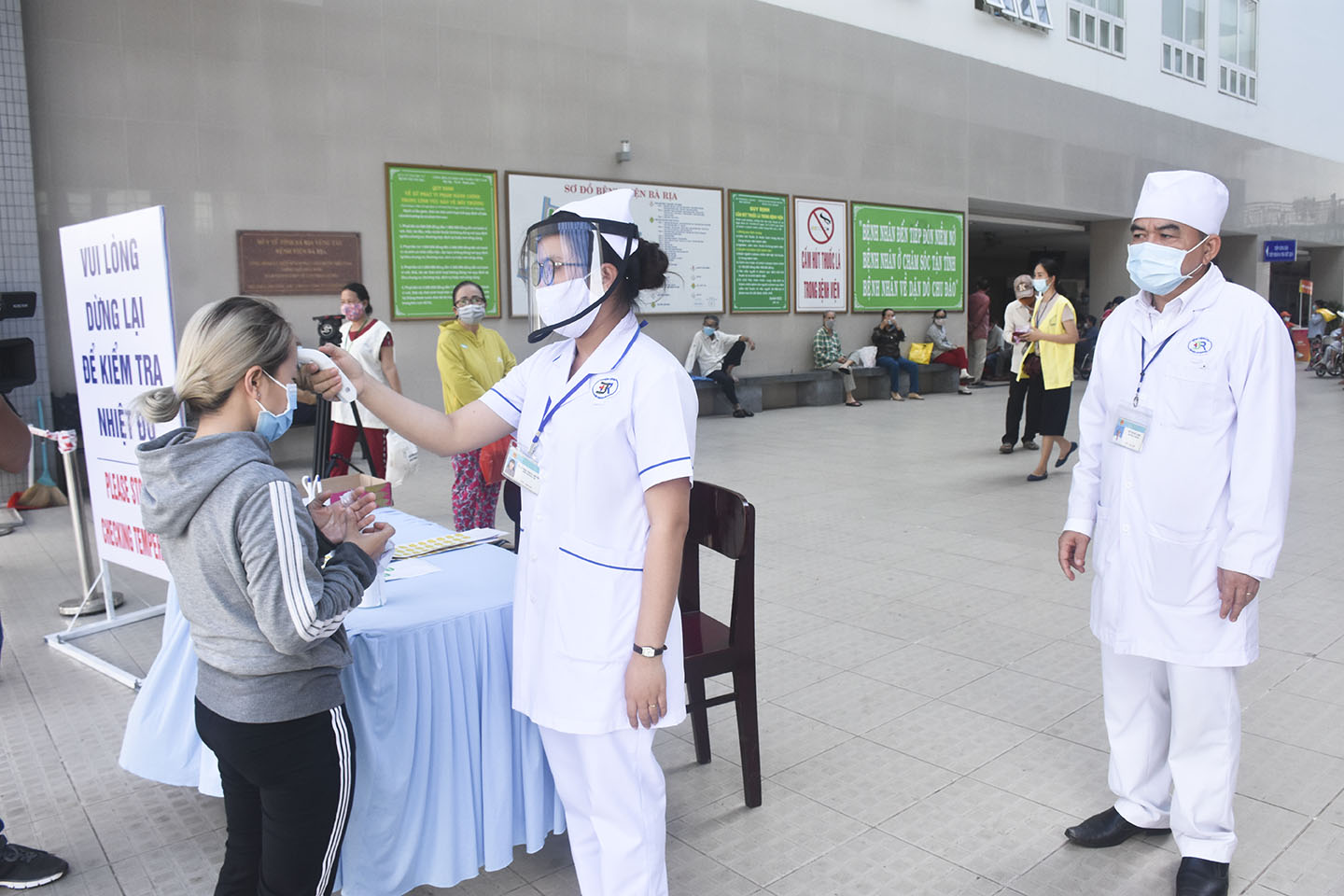 Nhân viên y tế kiểm tra thân nhiệt để sàng lọc COVID-19 cho người vào Bệnh viện Bà Rịa