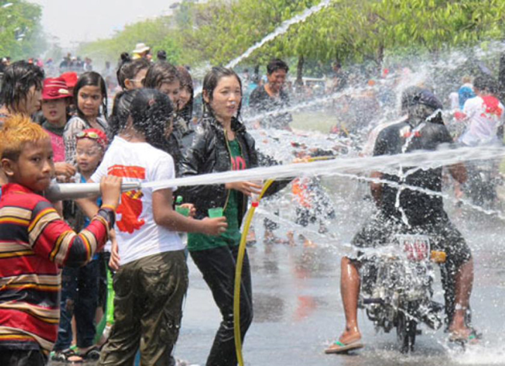 Kéo cả vòi tưới cây trong nhà ra để vui lễ té nước.