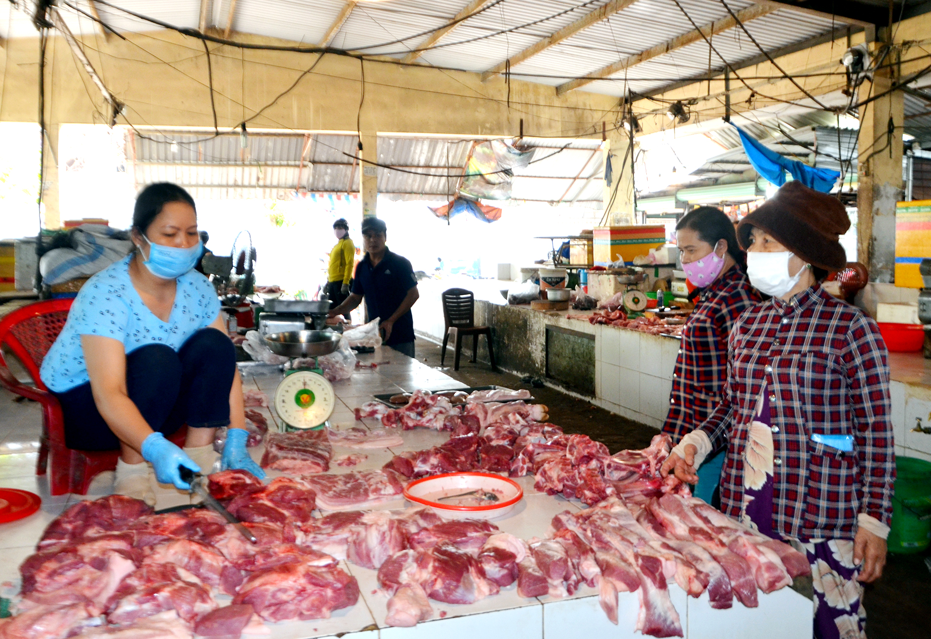 Tiểu thương và người đi chợ Tân Thành đều đeo khẩu trang khi mua bán. Ảnh: MINH THANH