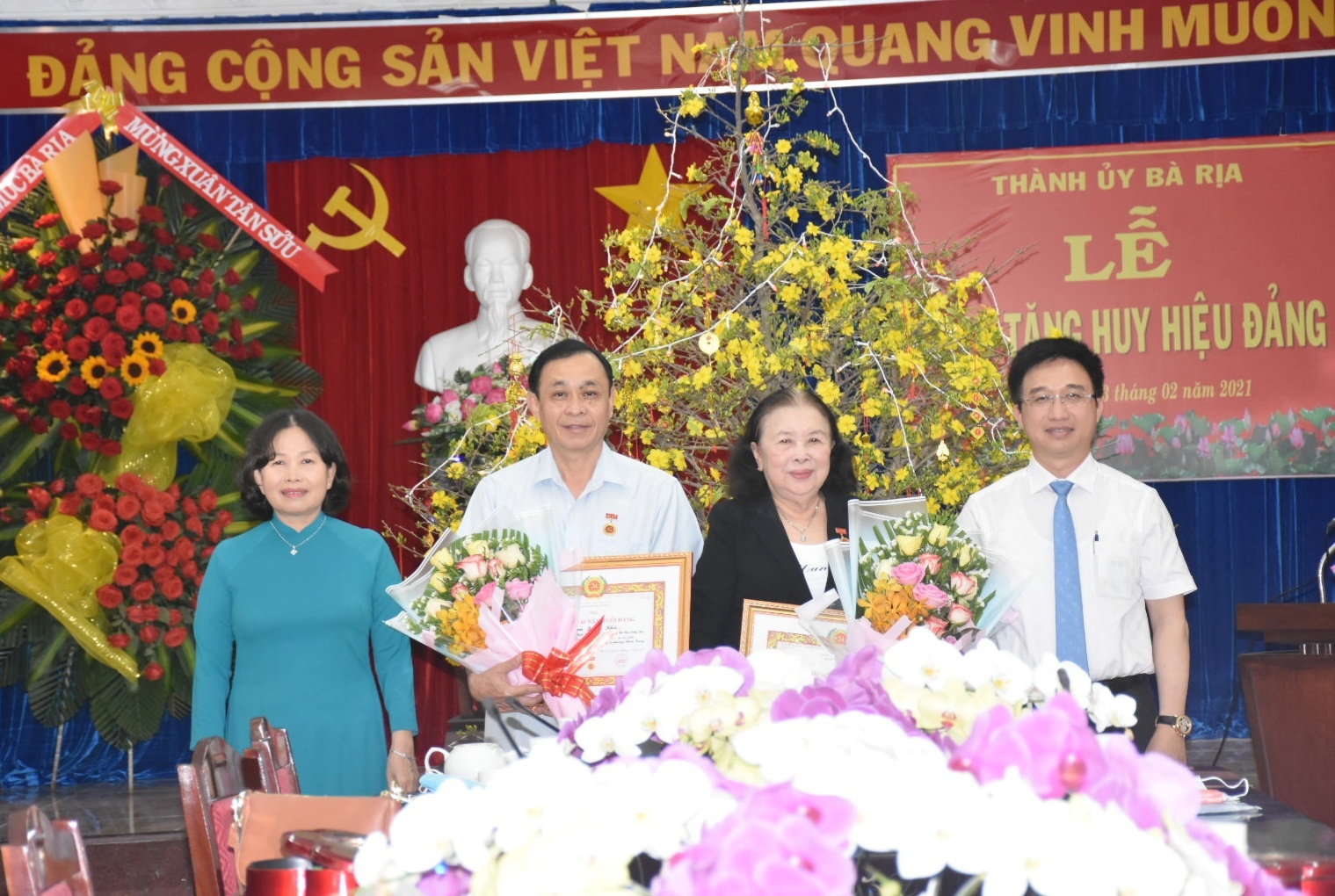 Bà Nguyễn Thị Yến, Phó Bí thư Thường trực Tỉnh ủy và ông Đặng Minh Thông, Ủy viên Ban Thường vụ Tỉnh ủy, Bí thư Thành ủy Bà Rịa  trao Huy hiệu Đảng và tặng hoa chúc mừng các đảng viên. Ảnh: TUYẾT MAI