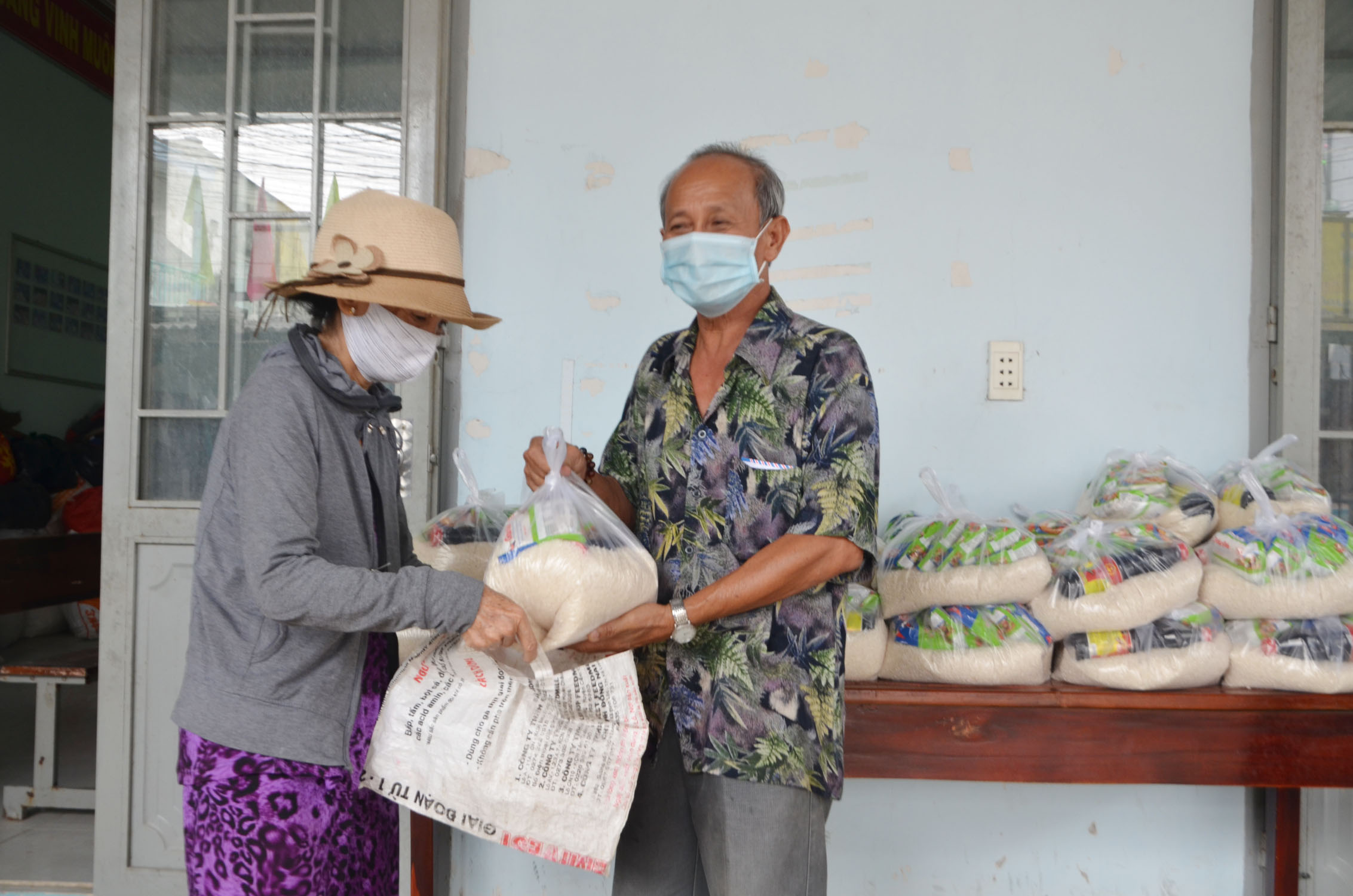Ông Trương Công Tấn, Trưởng Ban công tác Mặt trận khu phố Ông Trịnh, phường Tân Phước trao gạo, mỳ cho người nghèo tại “Gian hàng 0 đồng”.
