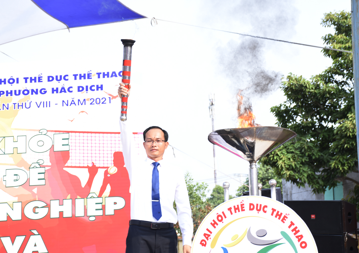 Ông Phan Minh Hợp, Bí thư Đảng uỷ phường Hắc Dịch thực hiện nghi thức châm lửa thắp sáng đài lửa của đại hội TDTT phường Hắc Dịch.